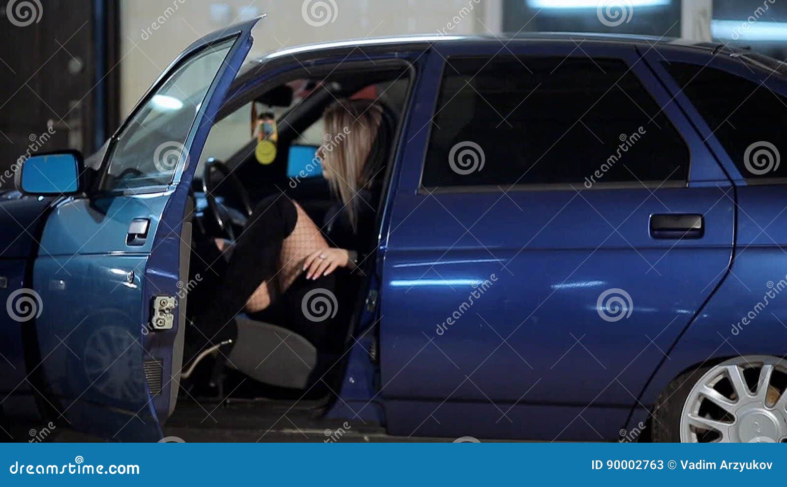 Girl in stockings and black leather boots in a car