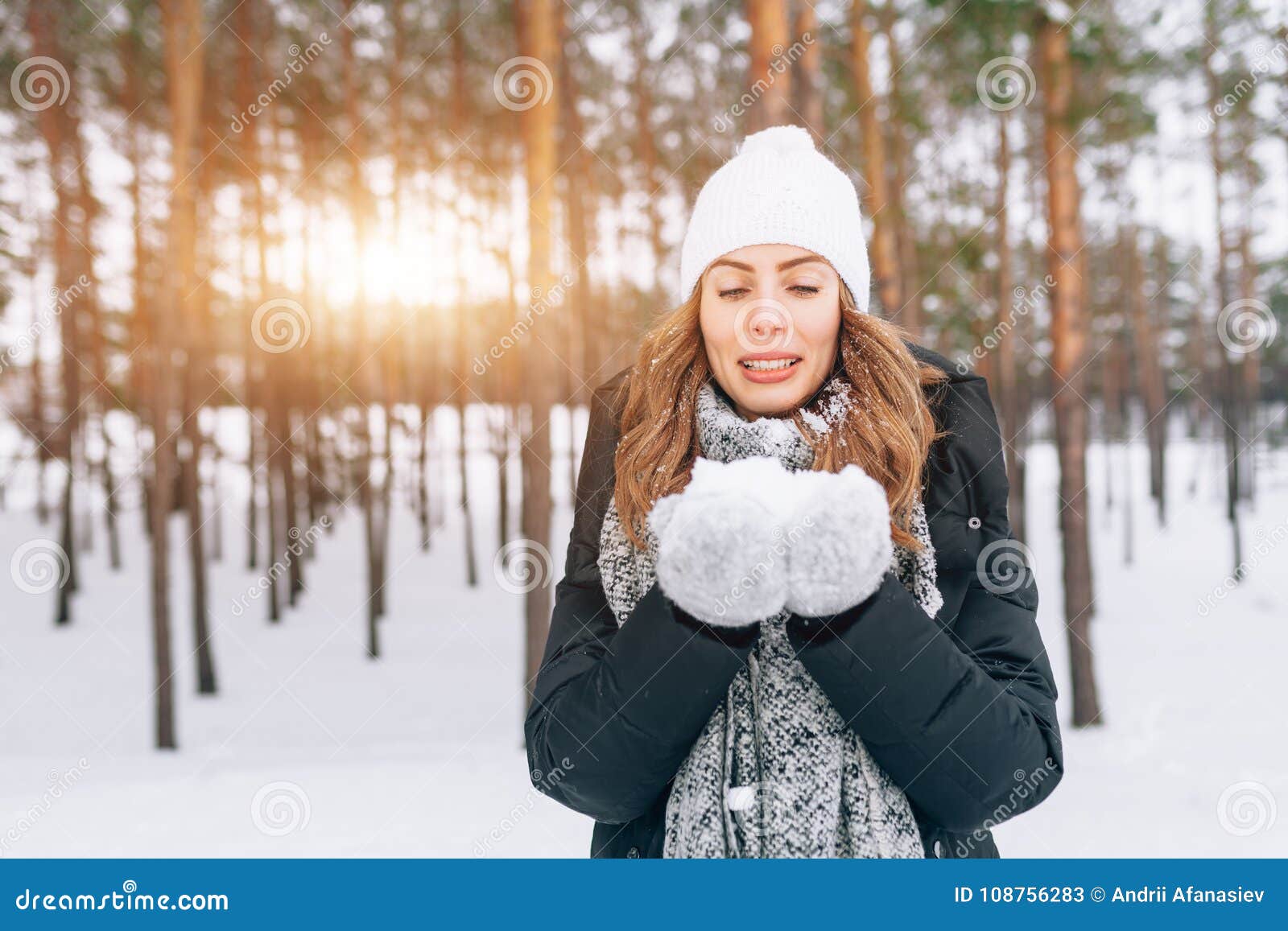 Beautiful Blonde Girl in White Woolen Hat Blowing on the Snow in Stock ...