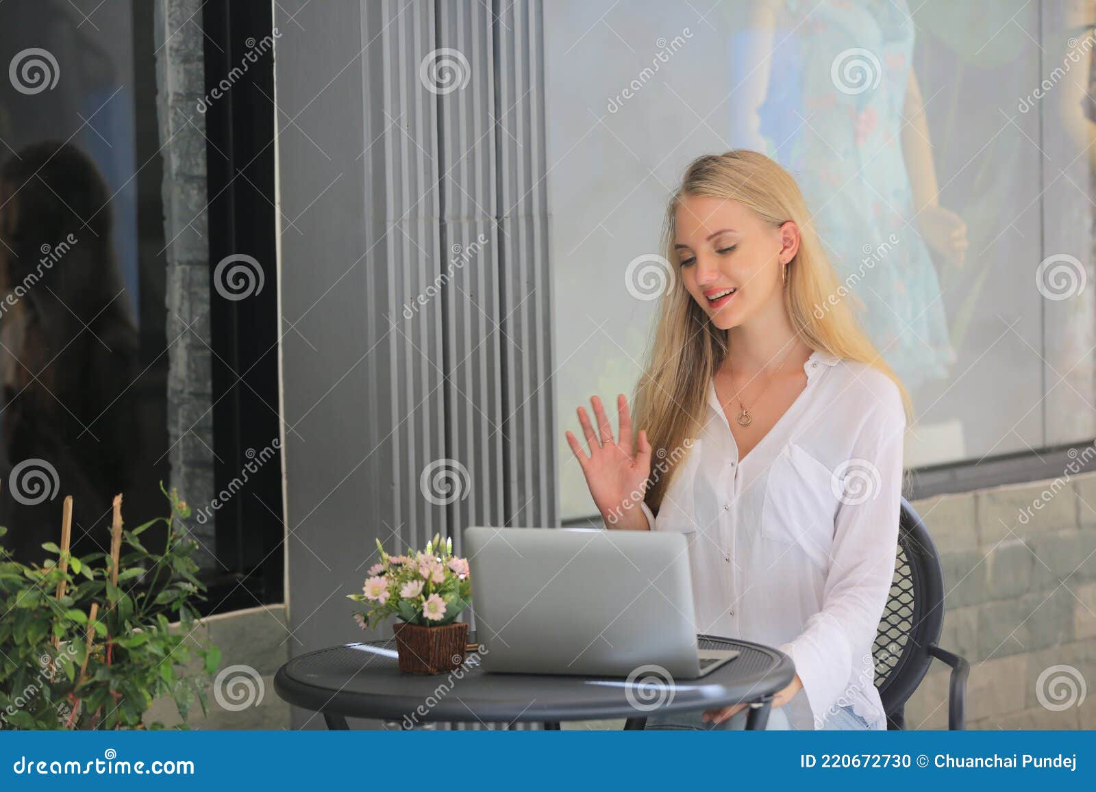 beautiful blonde hair girl sitting with laptop in front of retails shop,small business owner concept.