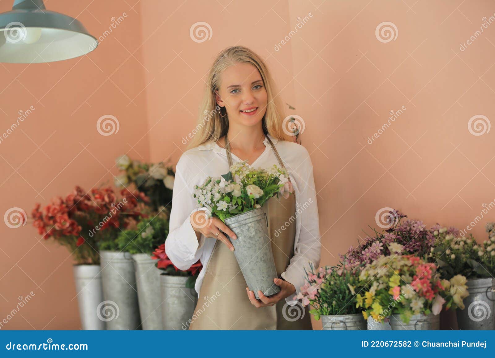 beautiful blonde hair girl standing with confidence in front of flower in open retails flora shop. small business owner concept