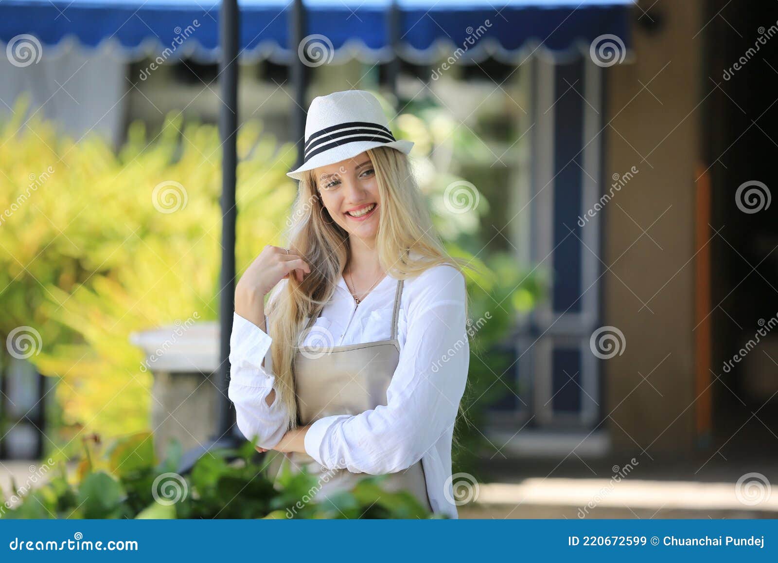 beautiful blonde hair girl standing with confidence in front of flower in open retails flora shop. small business owner concept