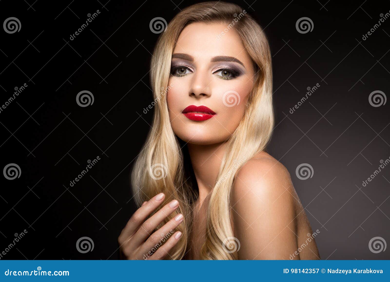 beautiful blonde model girl with long curly hair . hairstyle wavy curls . red lips.
