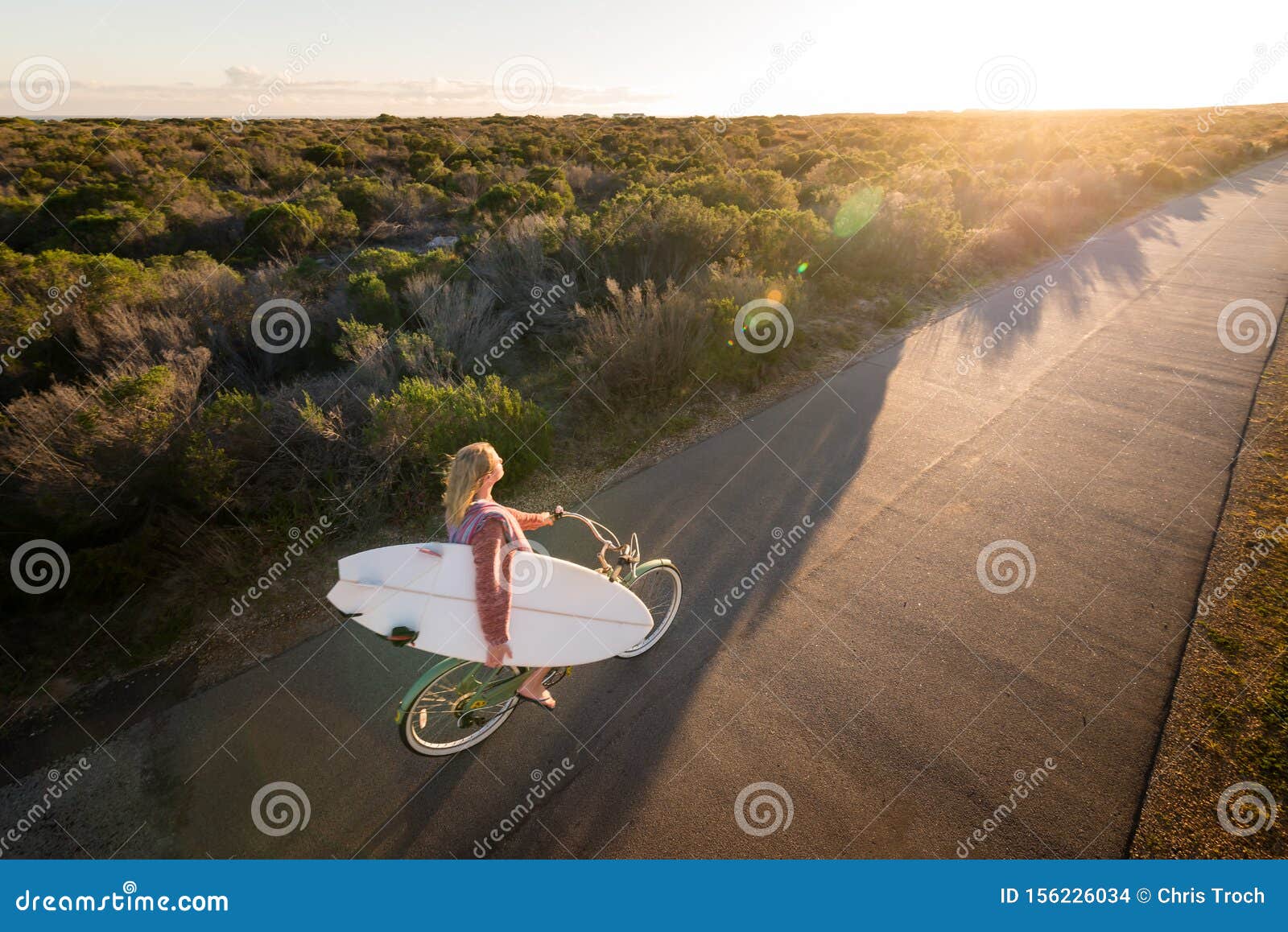 Beautiful Blonde Surfer Girl On Her Way To The Beach On Her Bicycle With Her Surfboard Stock 