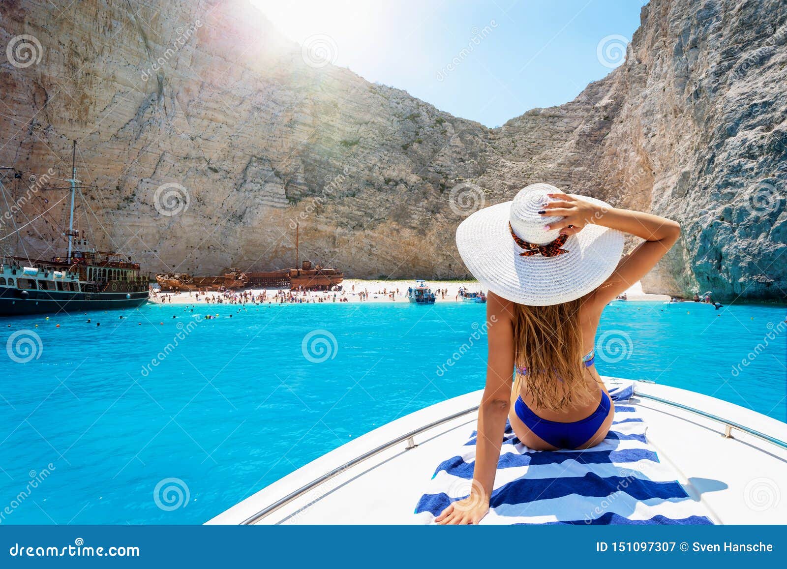 woman on a boat enjoys the view to the shipwreck beach, navagio in zakynthos, greece