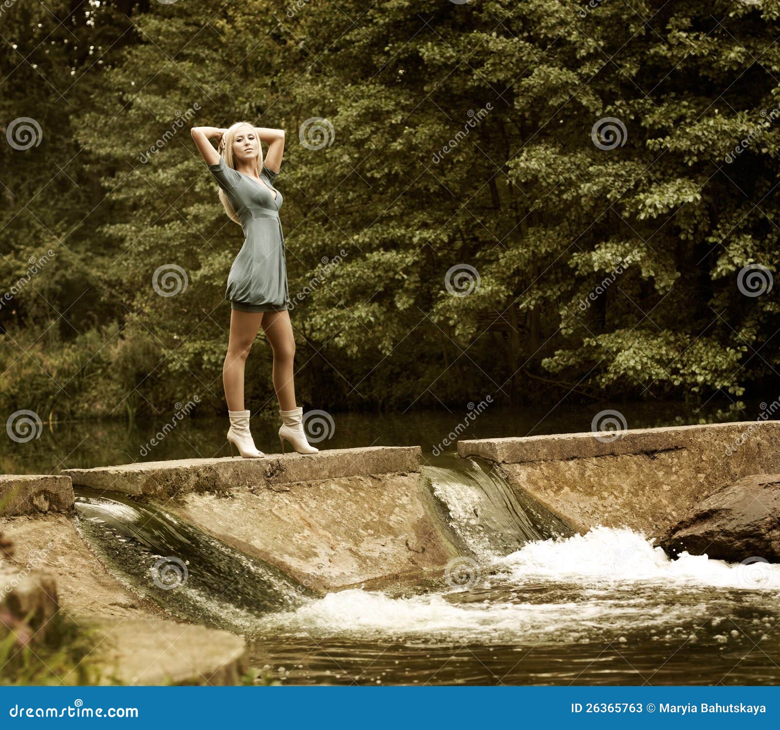 Beautiful Blonde Woman Standing Near The Waterfall Stock