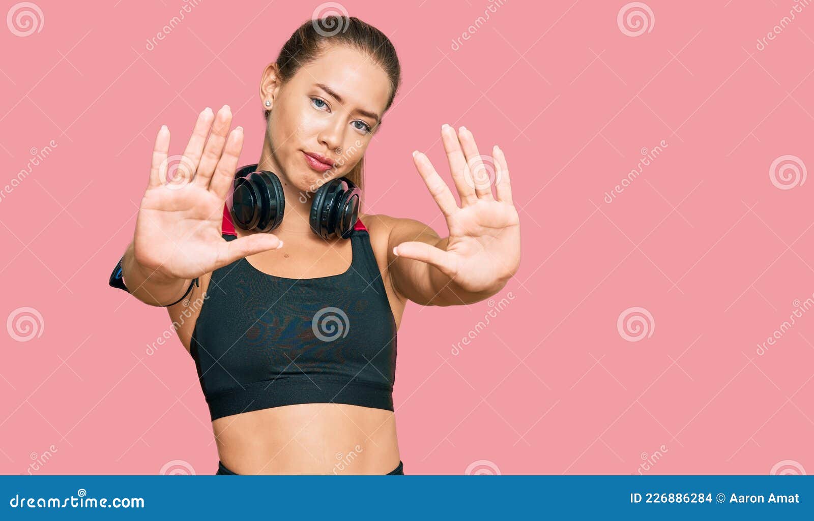 Beautiful Blonde Woman Wearing Gym Clothes And Using Headphones Doing Frame Using Hands Palms 4915