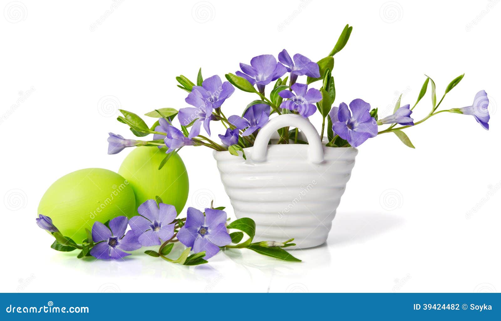 Beautiful Blue Periwinkle in the Basket and Green Eggs Stock Photo