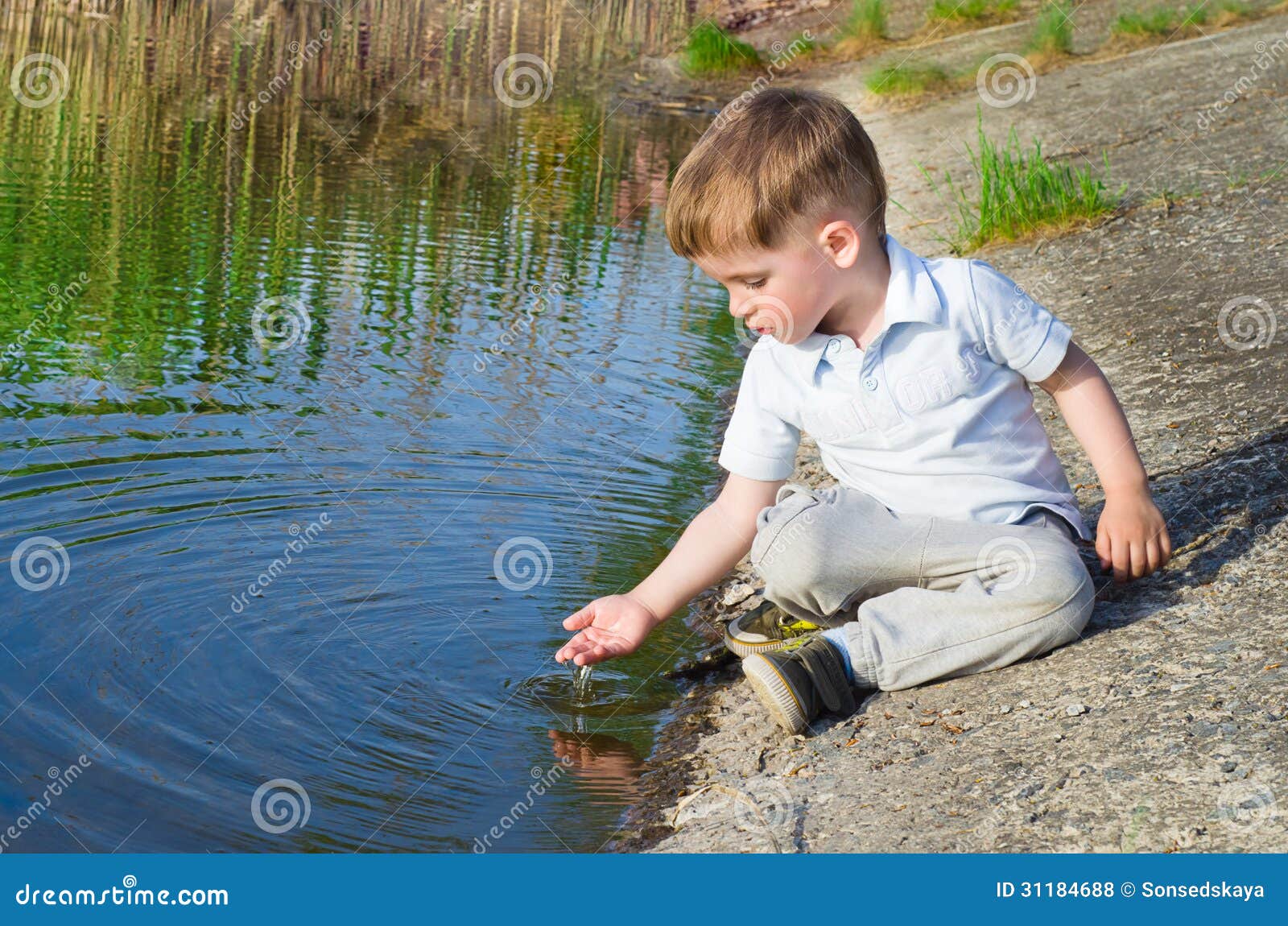 beautiful boy pours water from the palm