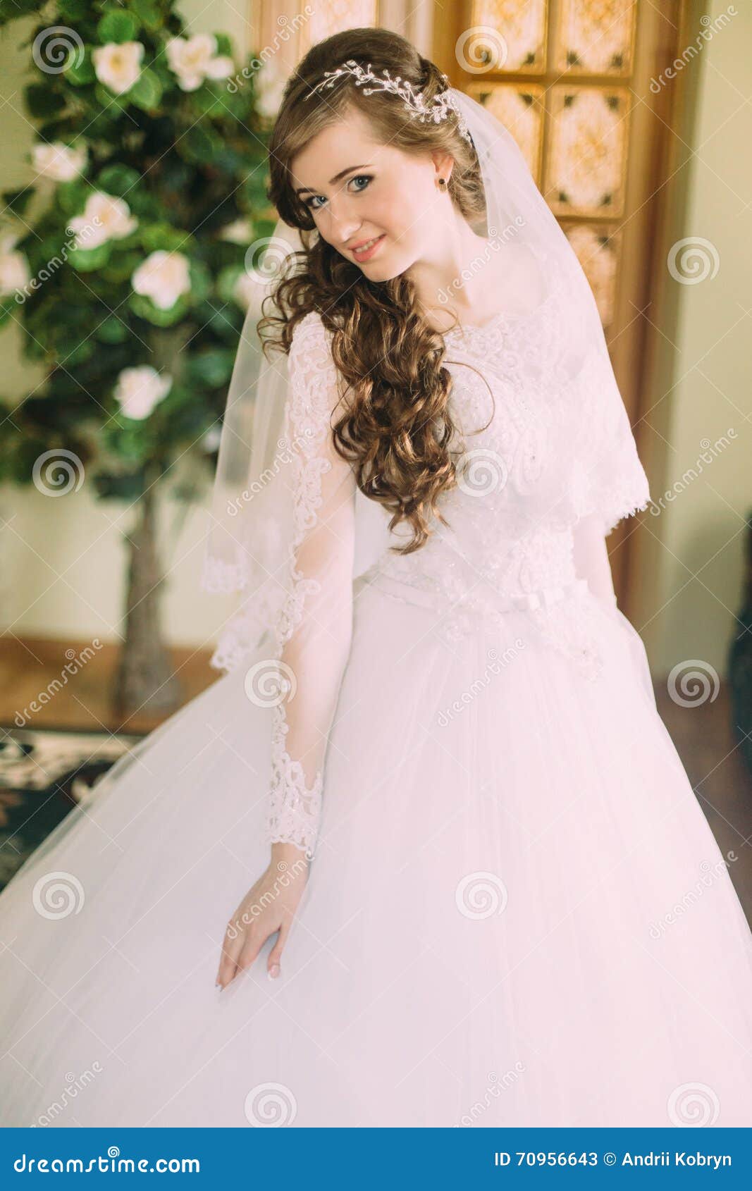 The Bride With Long Brown Curly Hair In A Wedding Dress Sitting At The  Mirror And Holds In Her Hands A Rose Stock Photo Picture And Royalty Free  Image Image 9764507
