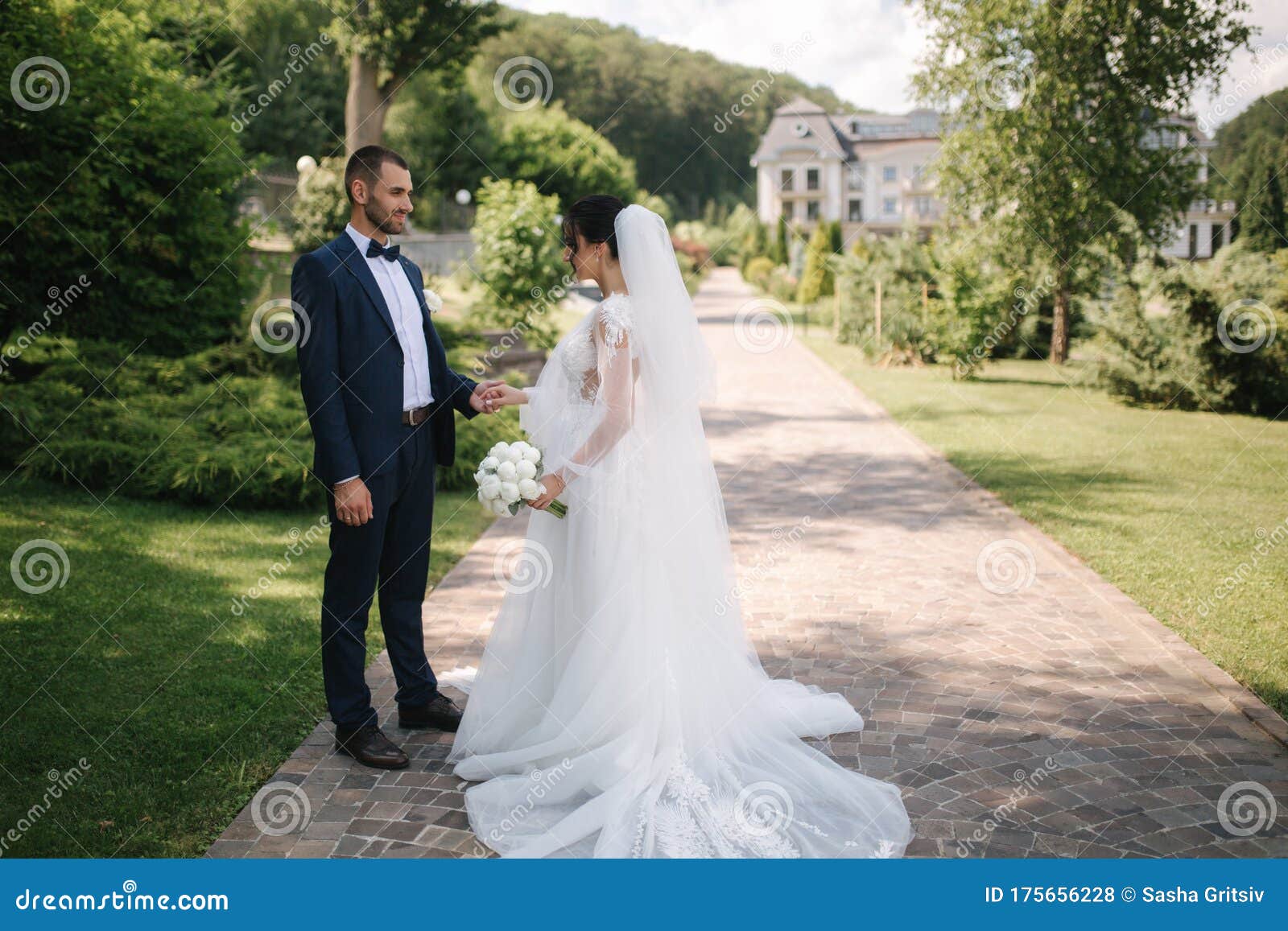 beautiful bride with her handsome groom walking outside on theri wedding day. happy newlyweds