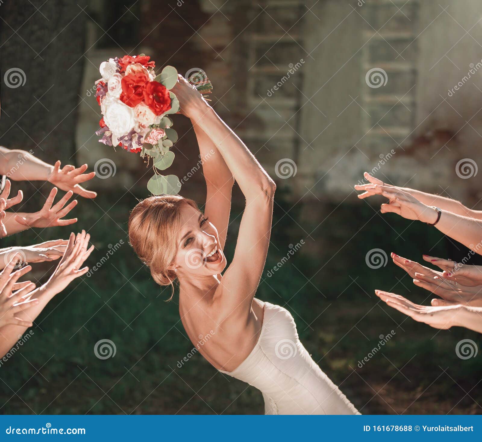 beautiful bride throws wedding bouquet to her friends