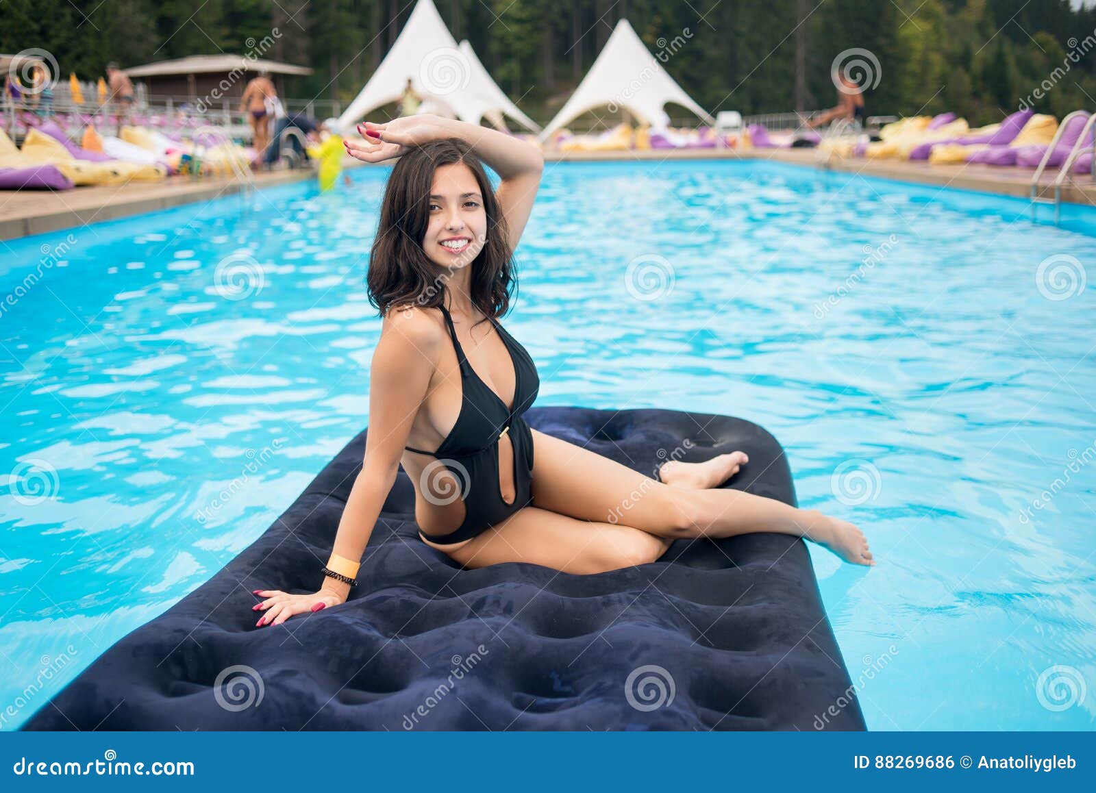 Beautiful Brunette Female In Black Bikini Lying On An Inflatable