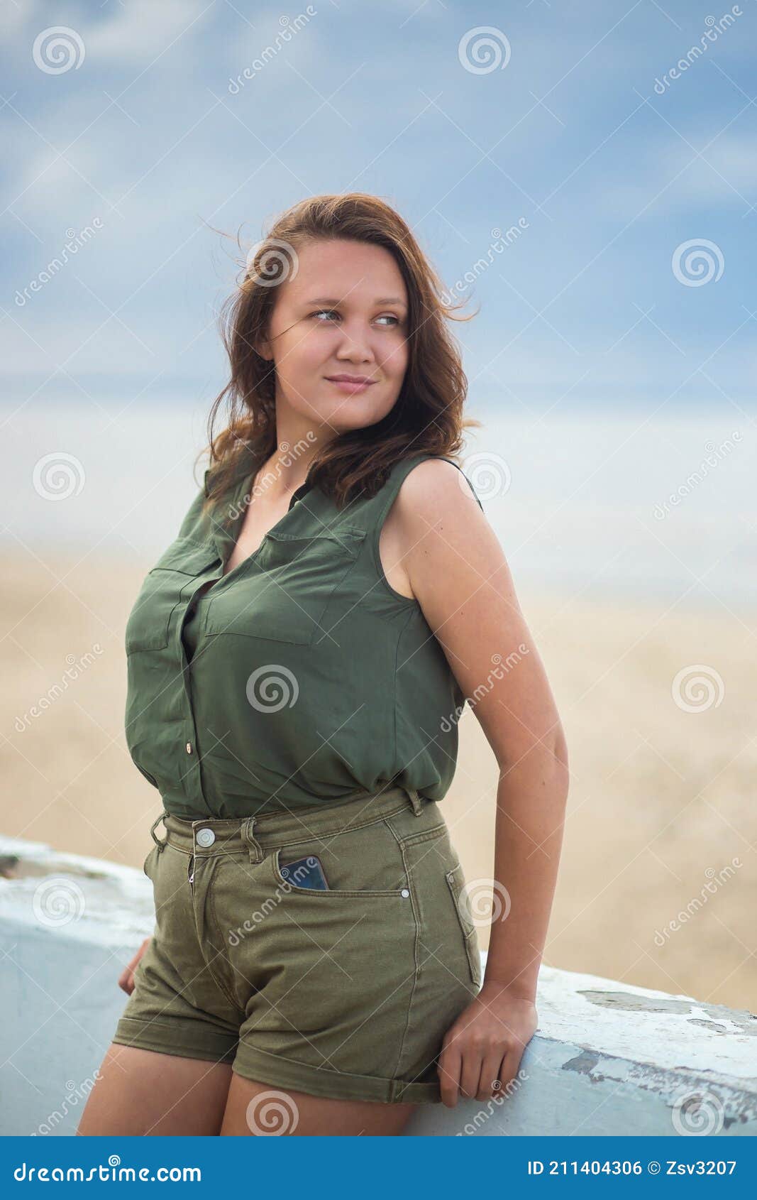 Beautiful Busty Curvy Woman in Olive Blouse and Shorts Posing Near the Sea  in the Atmospheric Cloudy Weather Stock Photo - Image of brunette,  plussized: 211404306