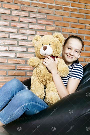 Beautiful Caucasian Teen Girl Sitting in Black Bean Bag Chair Holding ...