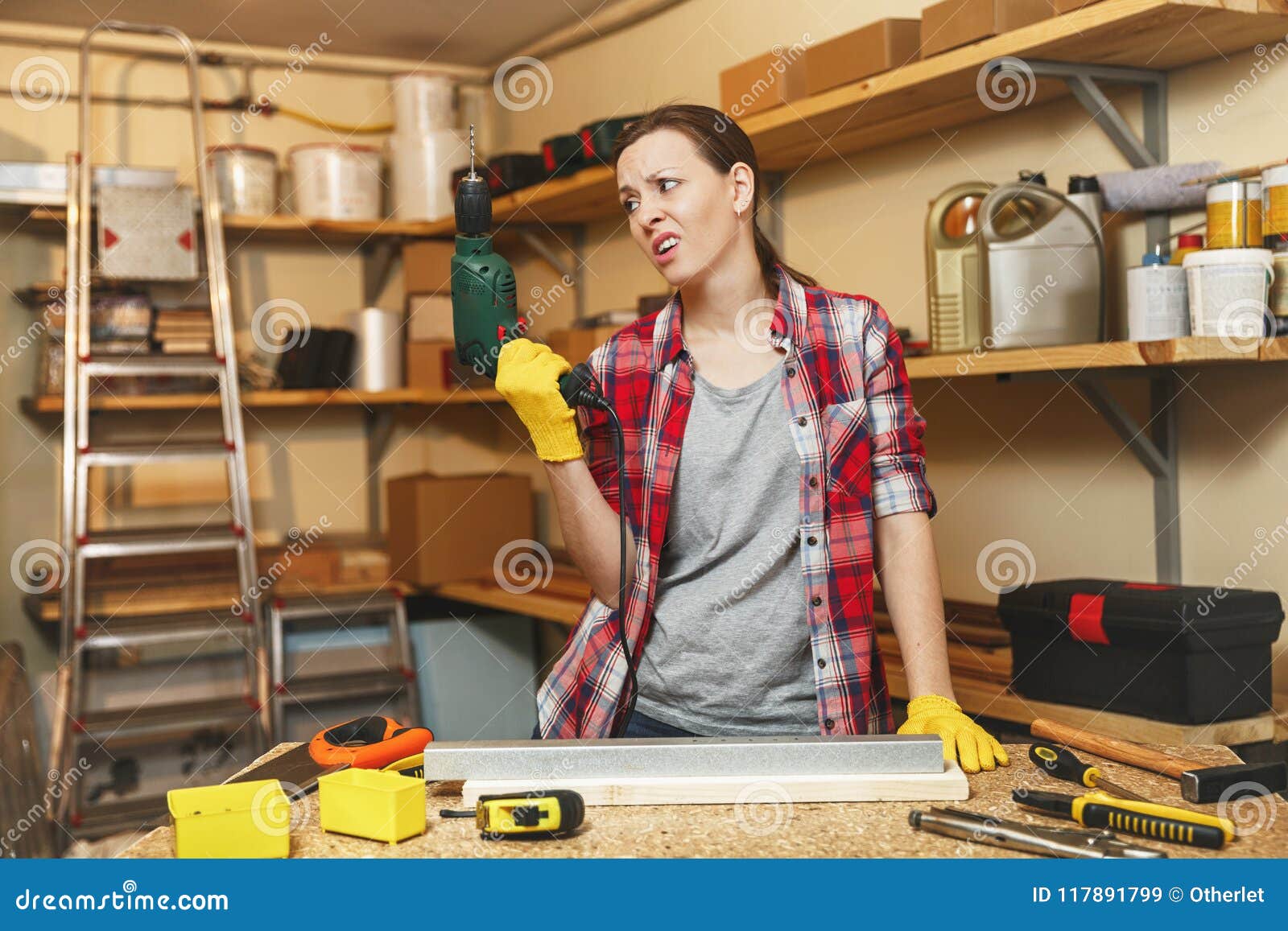 beautiful caucasian young brown-hair woman working in carpentry workshop at table place.