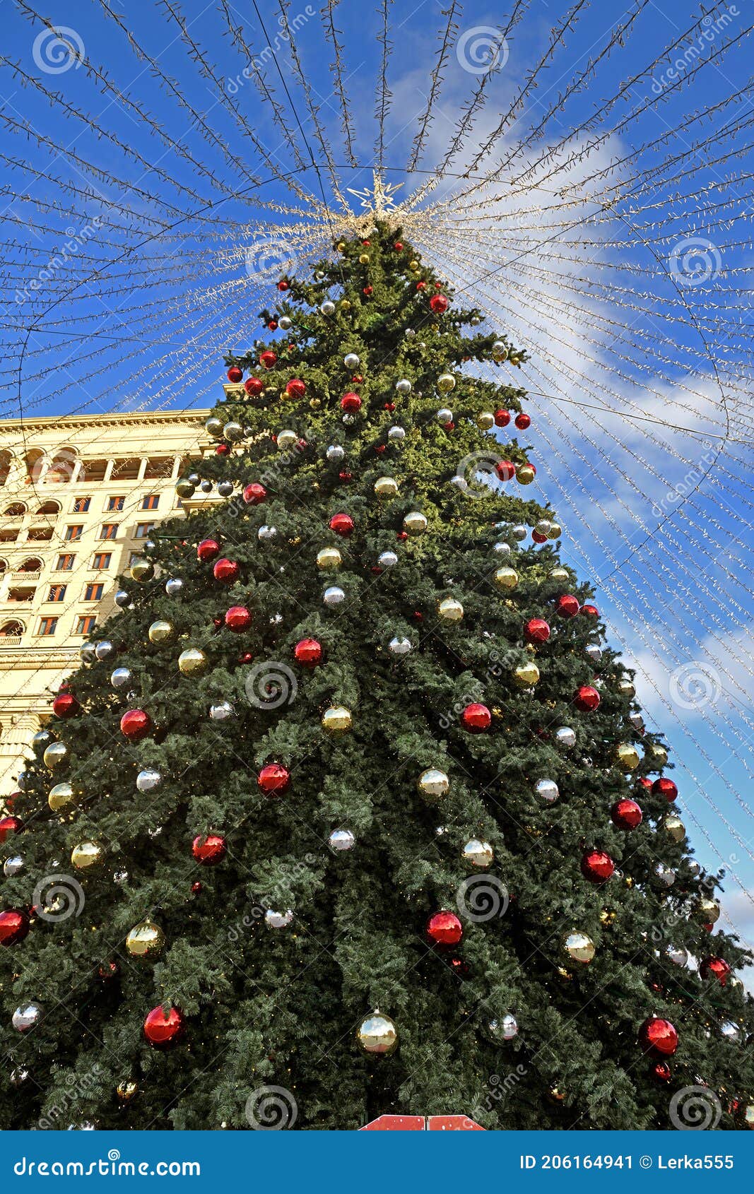 Beautiful Christmas Tree with Garland on Background of Blue Sky Stock