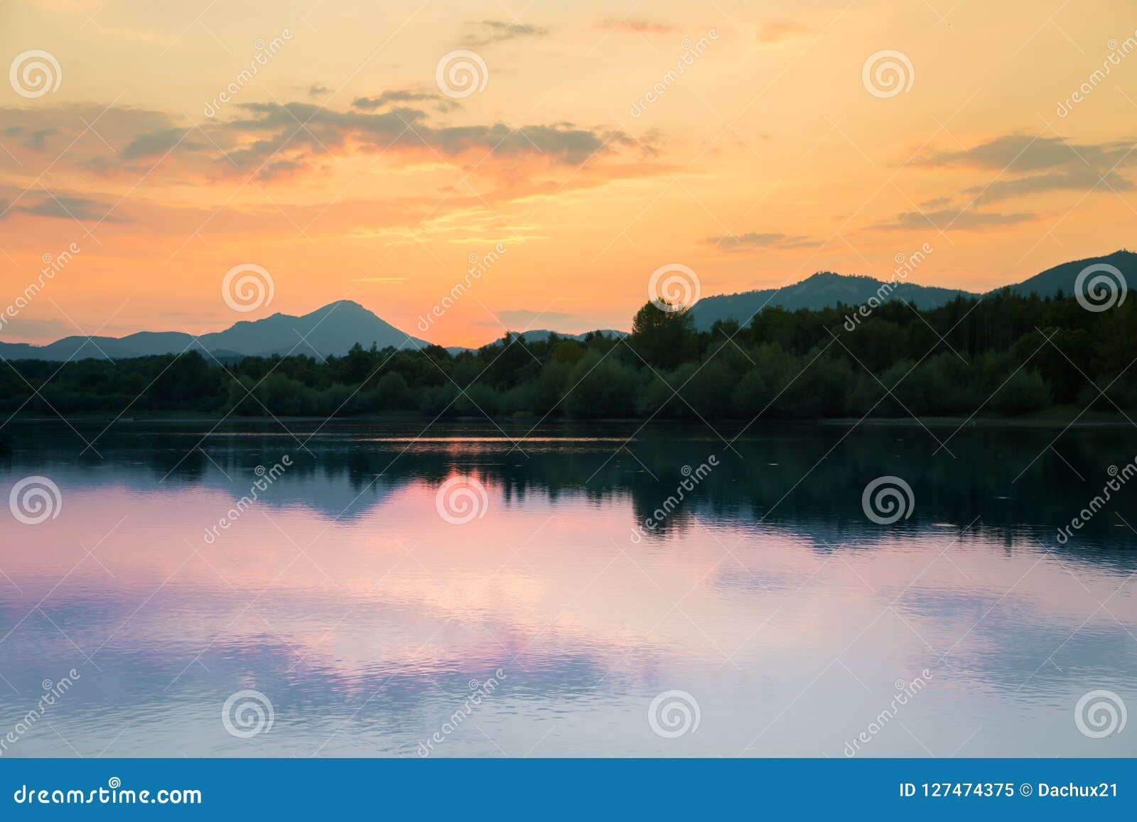 A Beautiful Colorful Sunset Landscape With Lake Mountain And Forest
