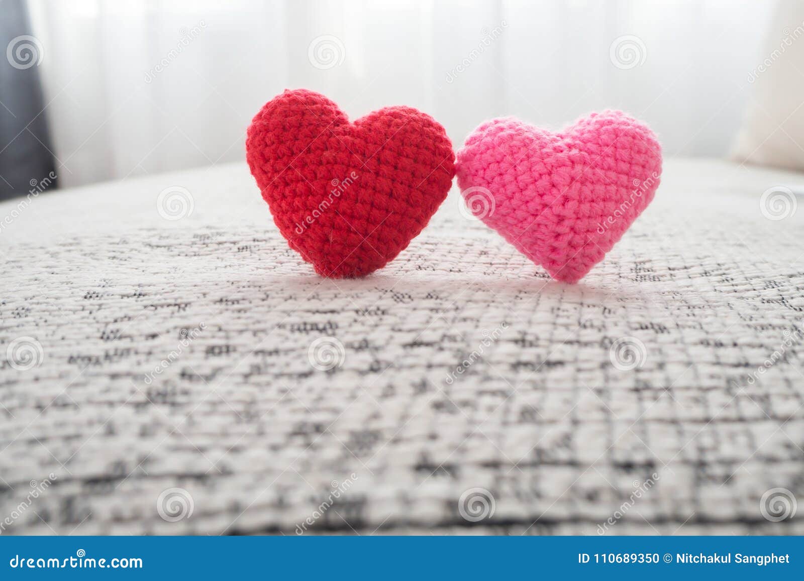 beautiful couple knitted fabric heart  on fabric sofa.