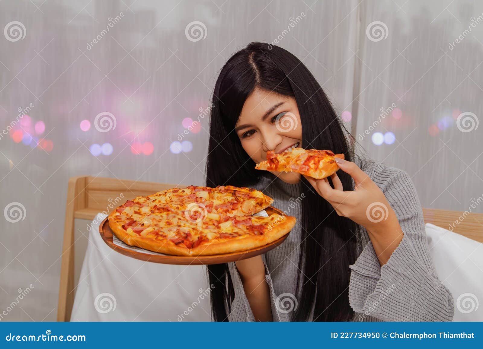 Beautiful And Delicious Asian Girl Sits And Looks At Pizza She Likes