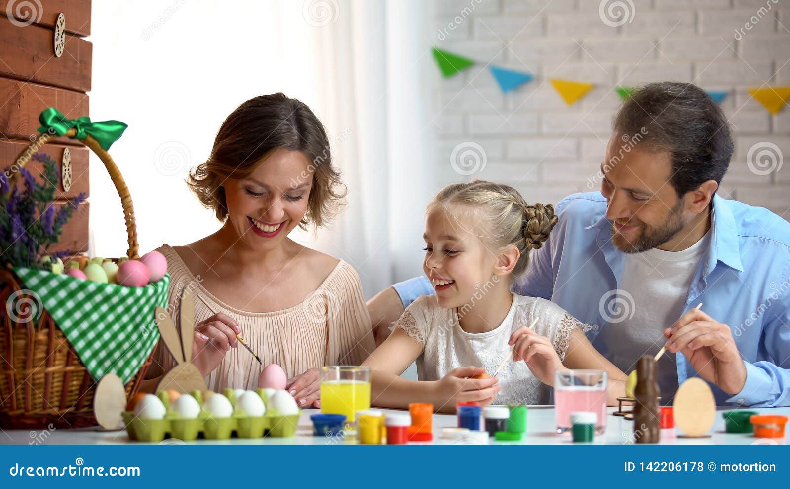 beautiful family decorating easter eggs with colorful paint, ancient traditions