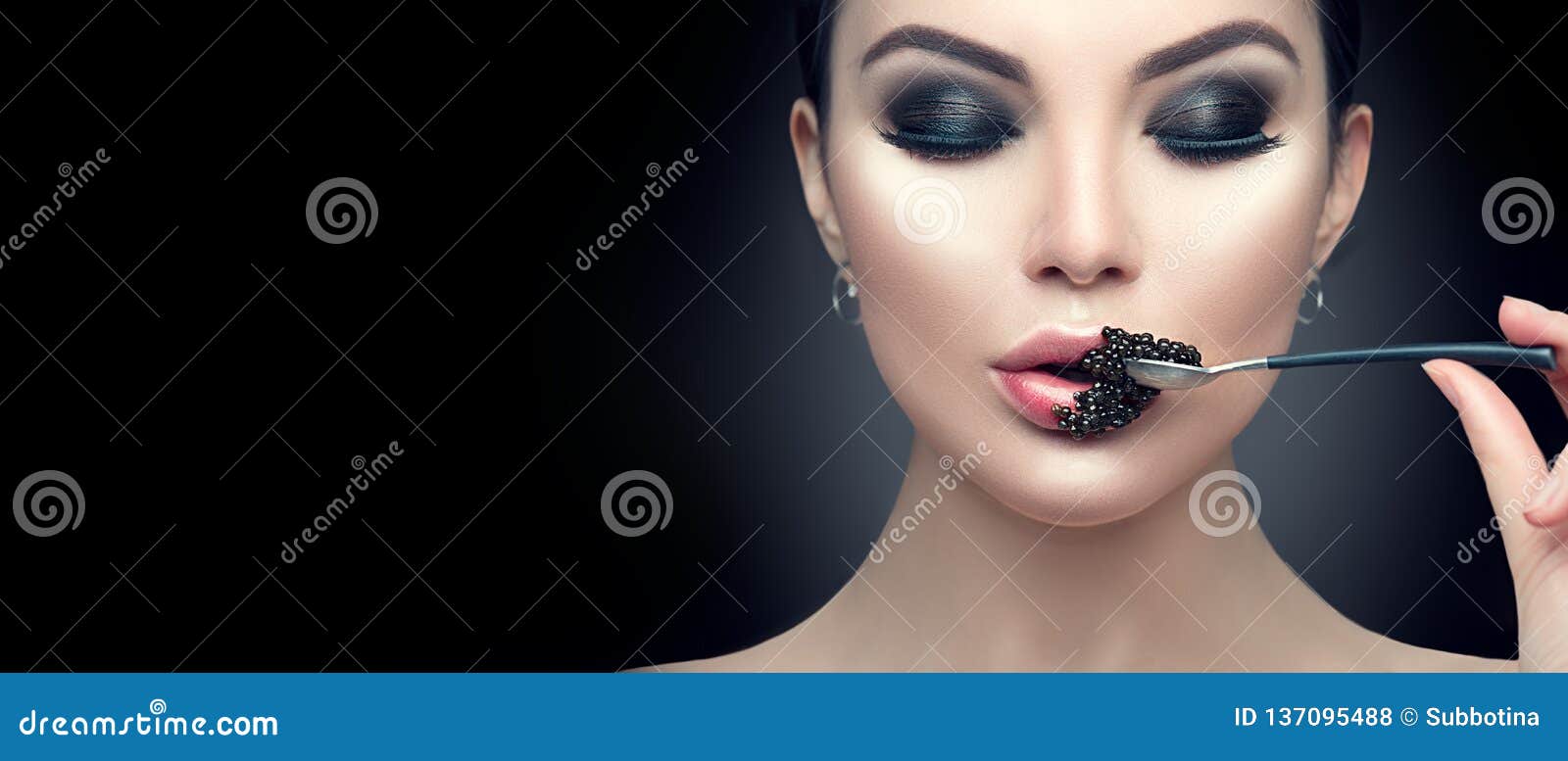 beautiful fashion model woman eating black caviar. beauty girl with caviar on her lips