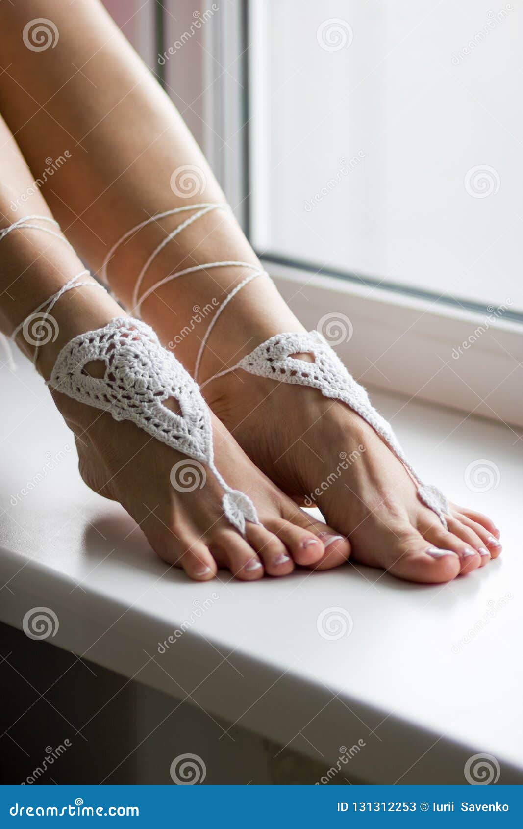Beautiful Female Feet on a Windowsill with Foot Jewelry Stock Image