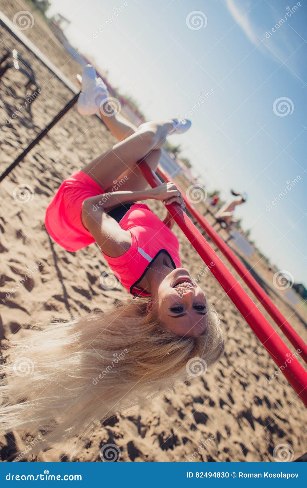 Young woman hanging upside down from pier - Stock Image 