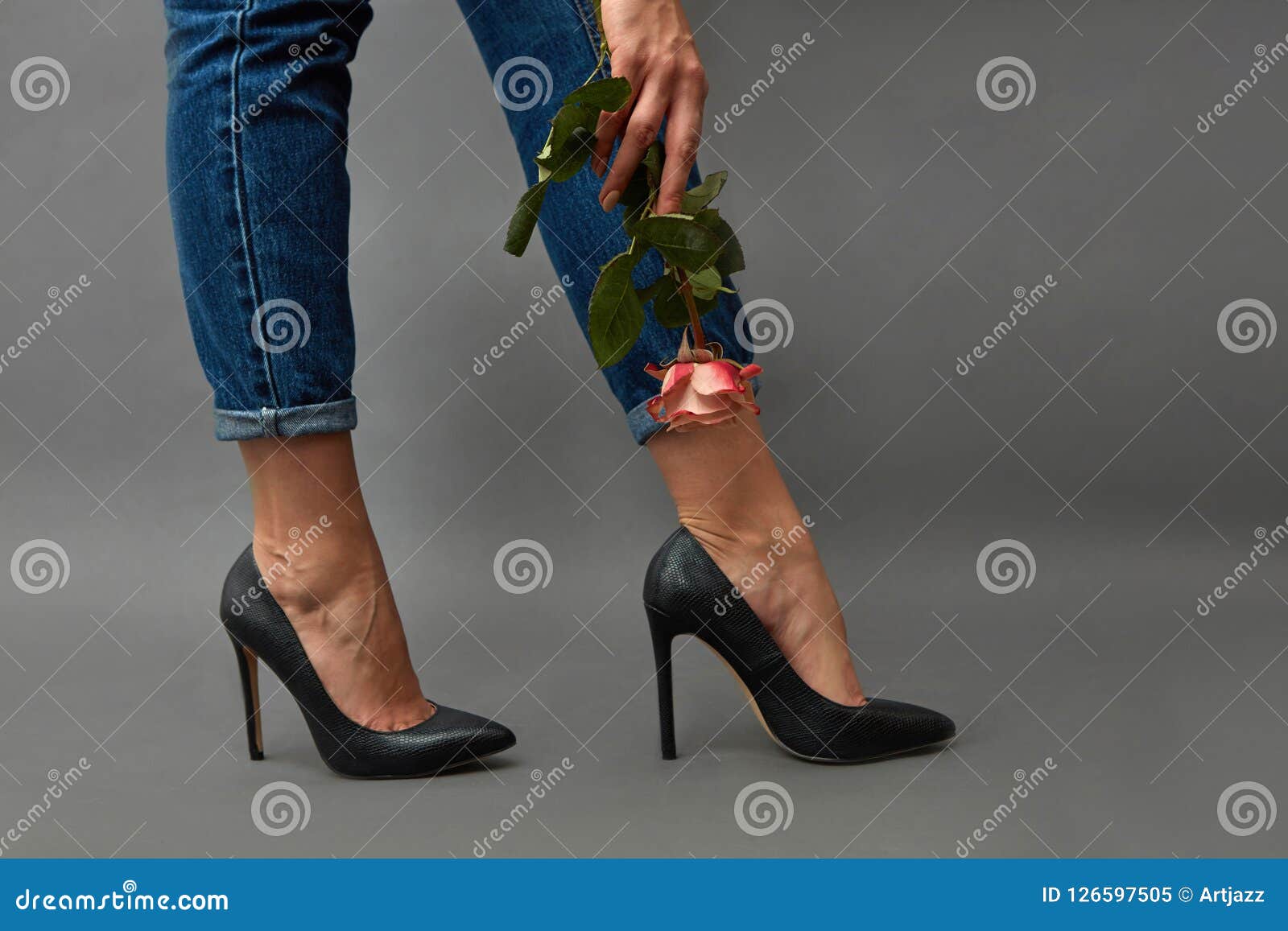 Beautiful young woman wearing a black jeans and high heels, sitting in cool  pose on the floor, portrait in front of white background Stock Photo |  Adobe Stock