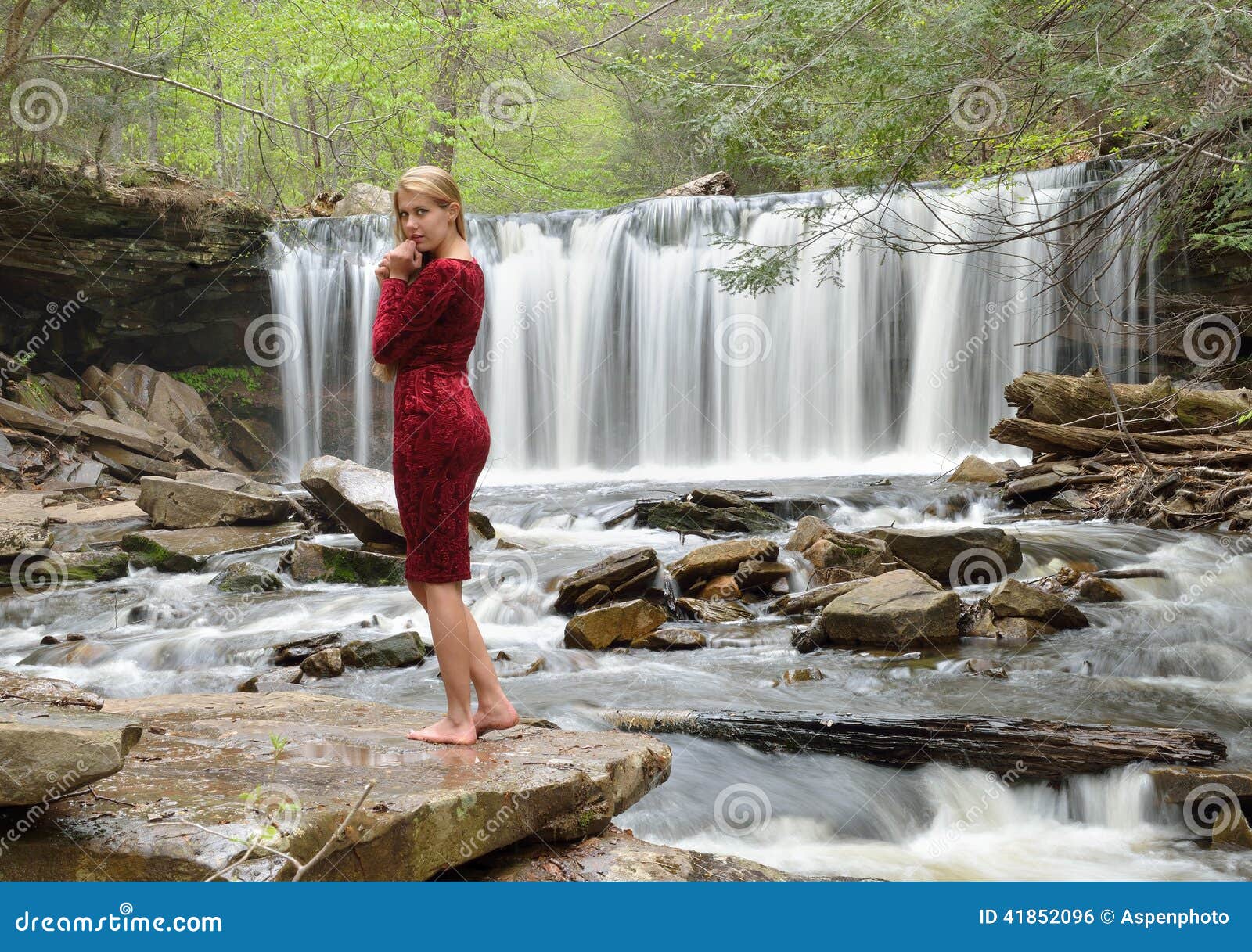 Young man smiling and standing in pose with big waterfall in the background  Stock Photo - Alamy
