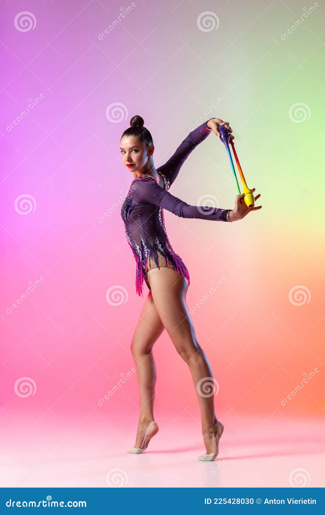 Beautiful Female Rhythmic Gymnast with Clubs Behind Her Back Isolated on  Multicolored Neon Background. Stock Photo - Image of grace, background:  225428030