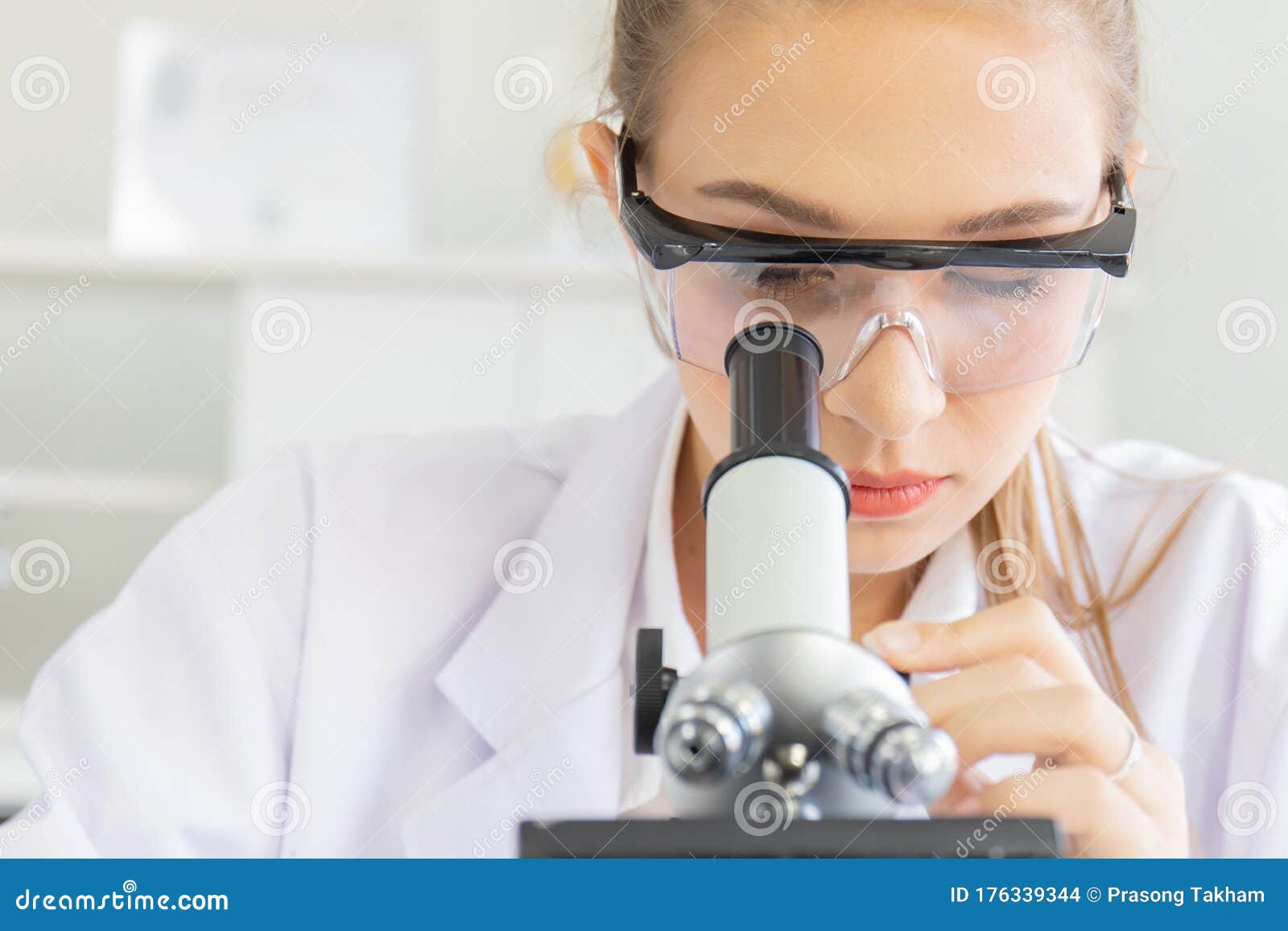 Beautiful Female Scientists are Looking at the Microscopes in a Science