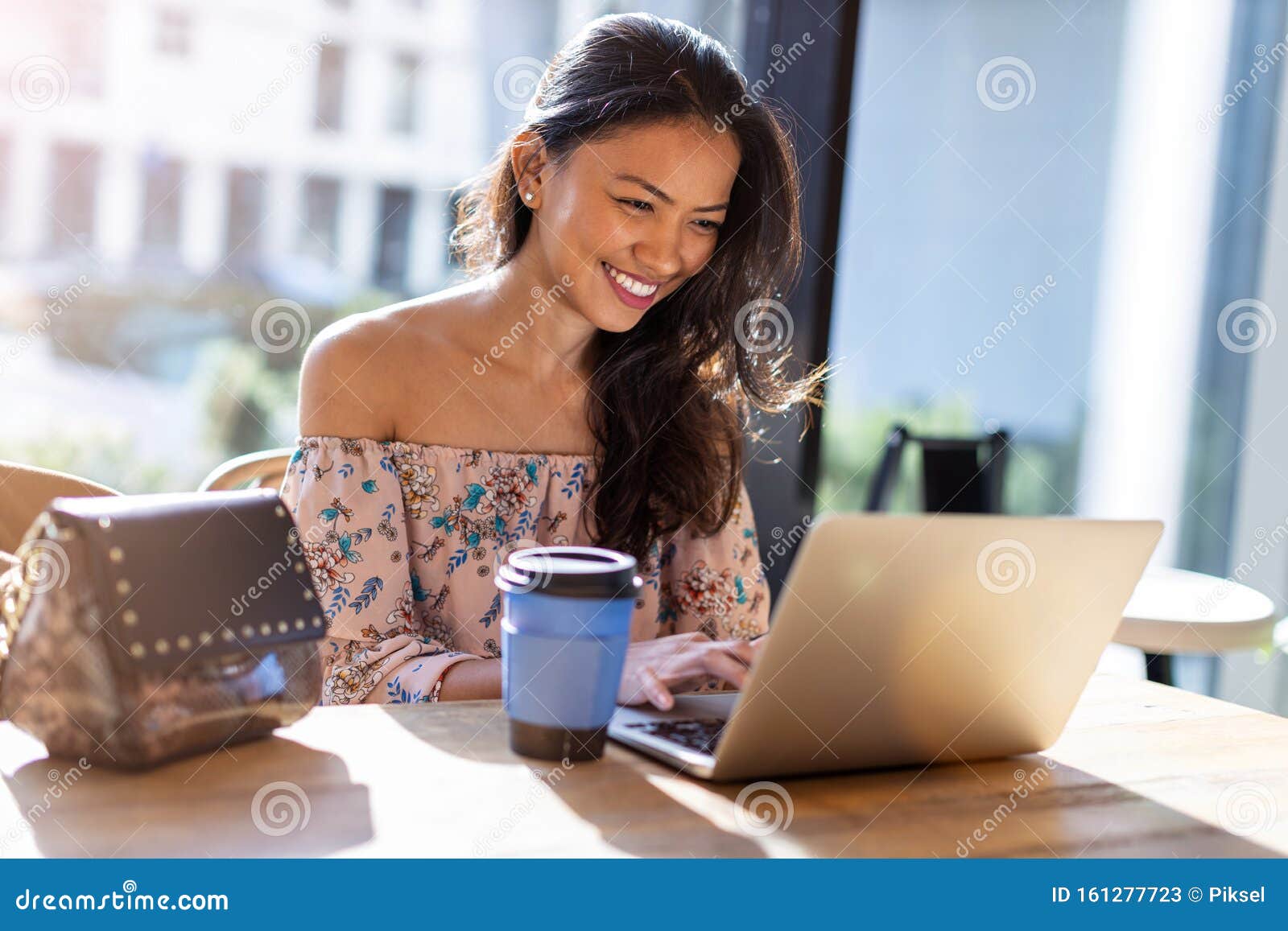 beautiful filipino woman using laptop at cafe
