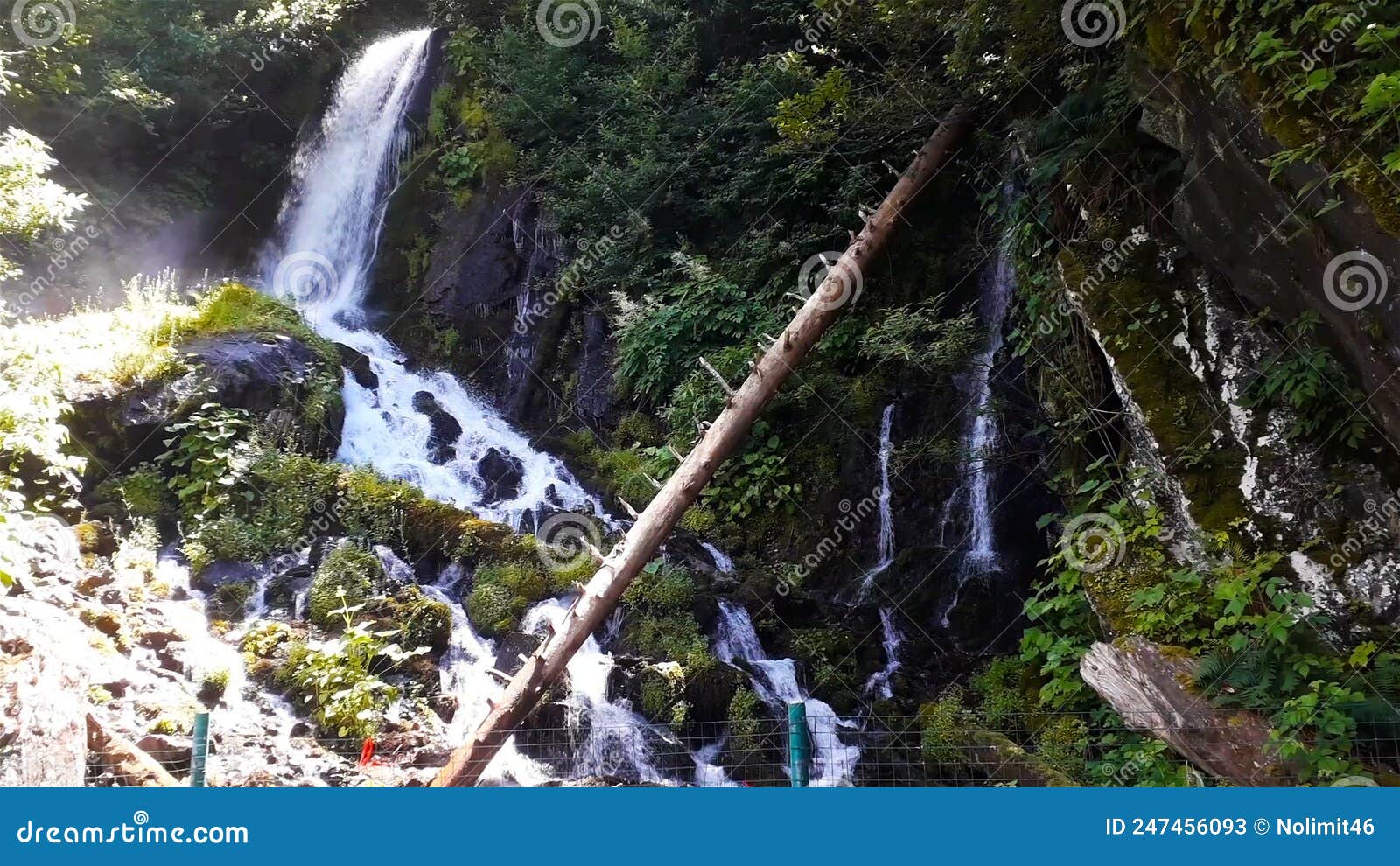 beautiful fresh waterfall among tall rocks witth greenery in sochi, russia