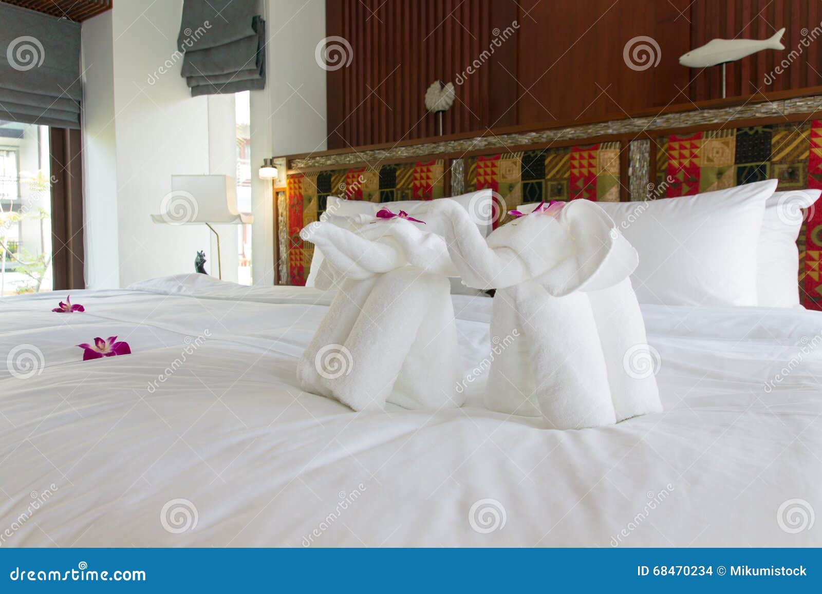 Beautiful Freshly Made Bed with Elephant Towel in the Tropics Stock