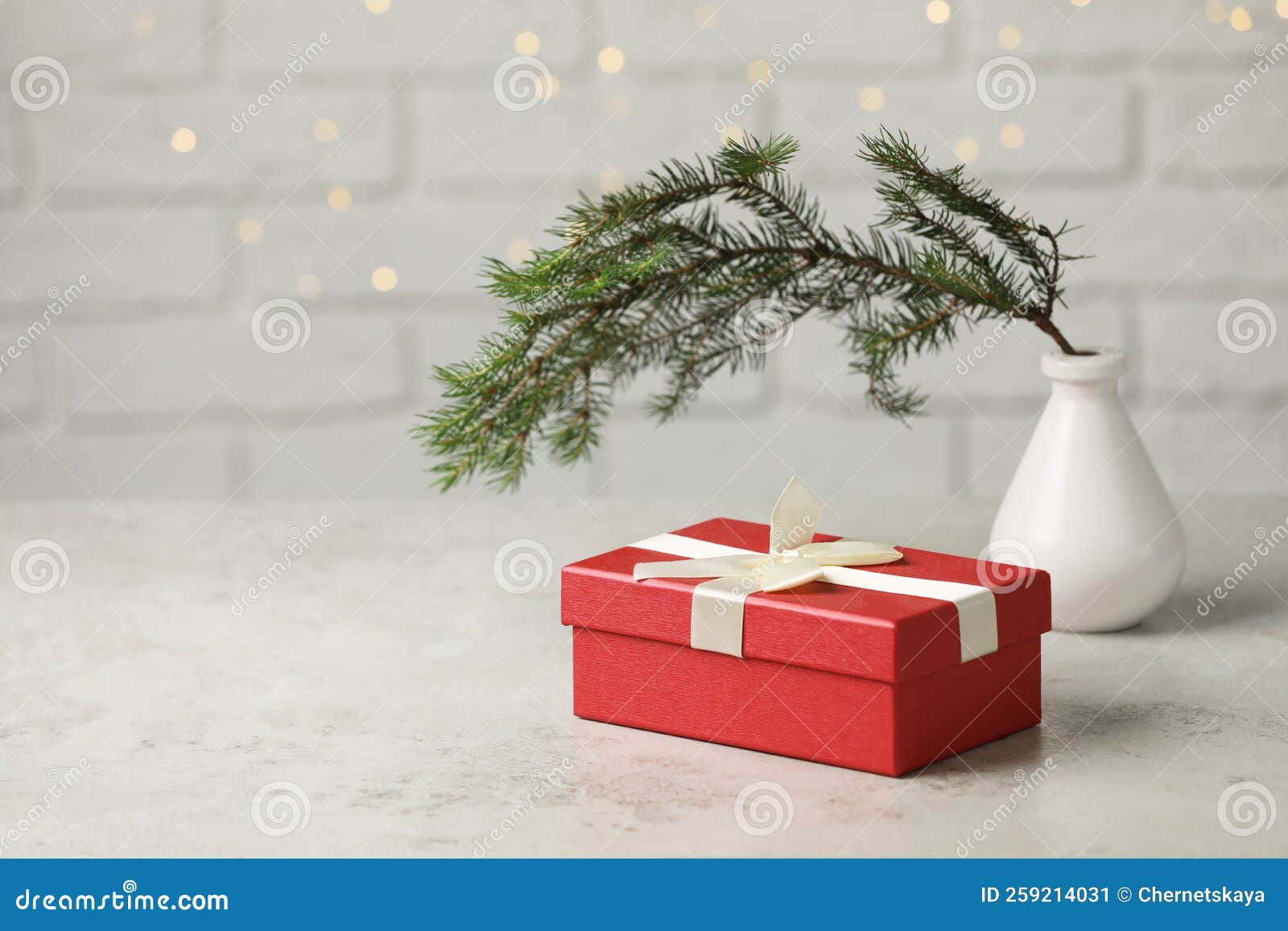 Beautiful Gift Box and Vase with Spruce Tree on Light Grey Table. Space