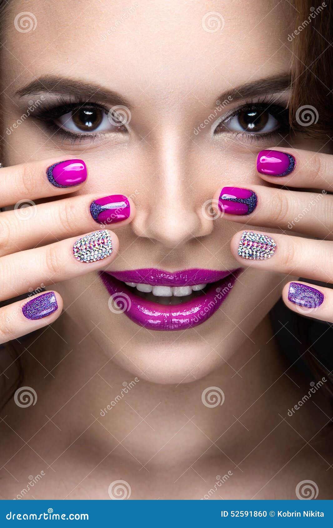 beautiful girl with a bright evening make-up and purple manicure with rhinestones. nail . beauty face.