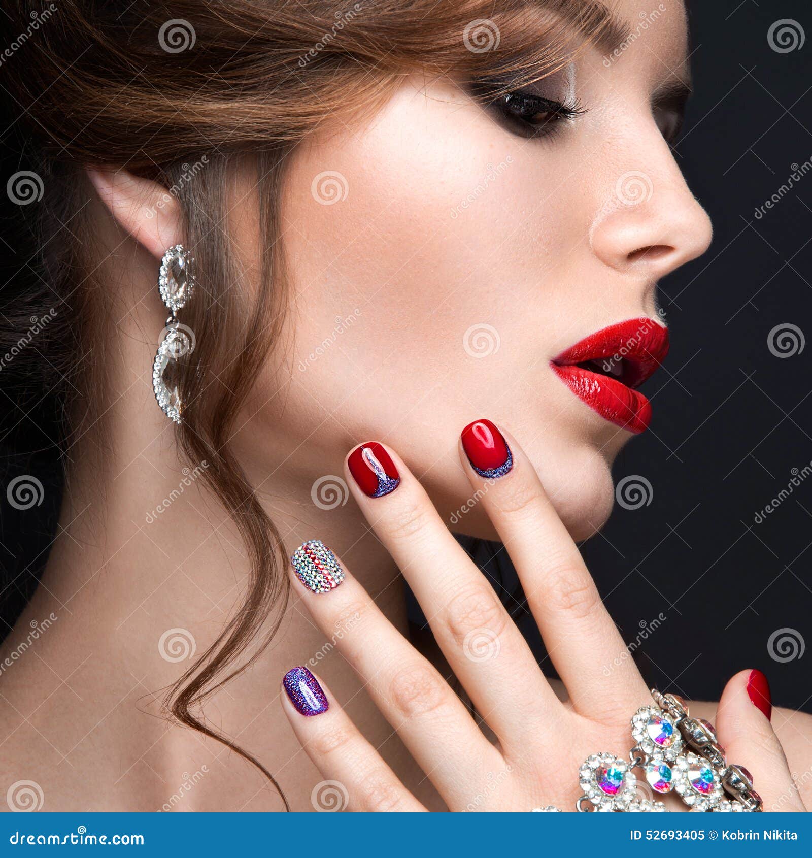 beautiful girl with a bright evening make-up and red manicure with rhinestones. nail . beauty face.