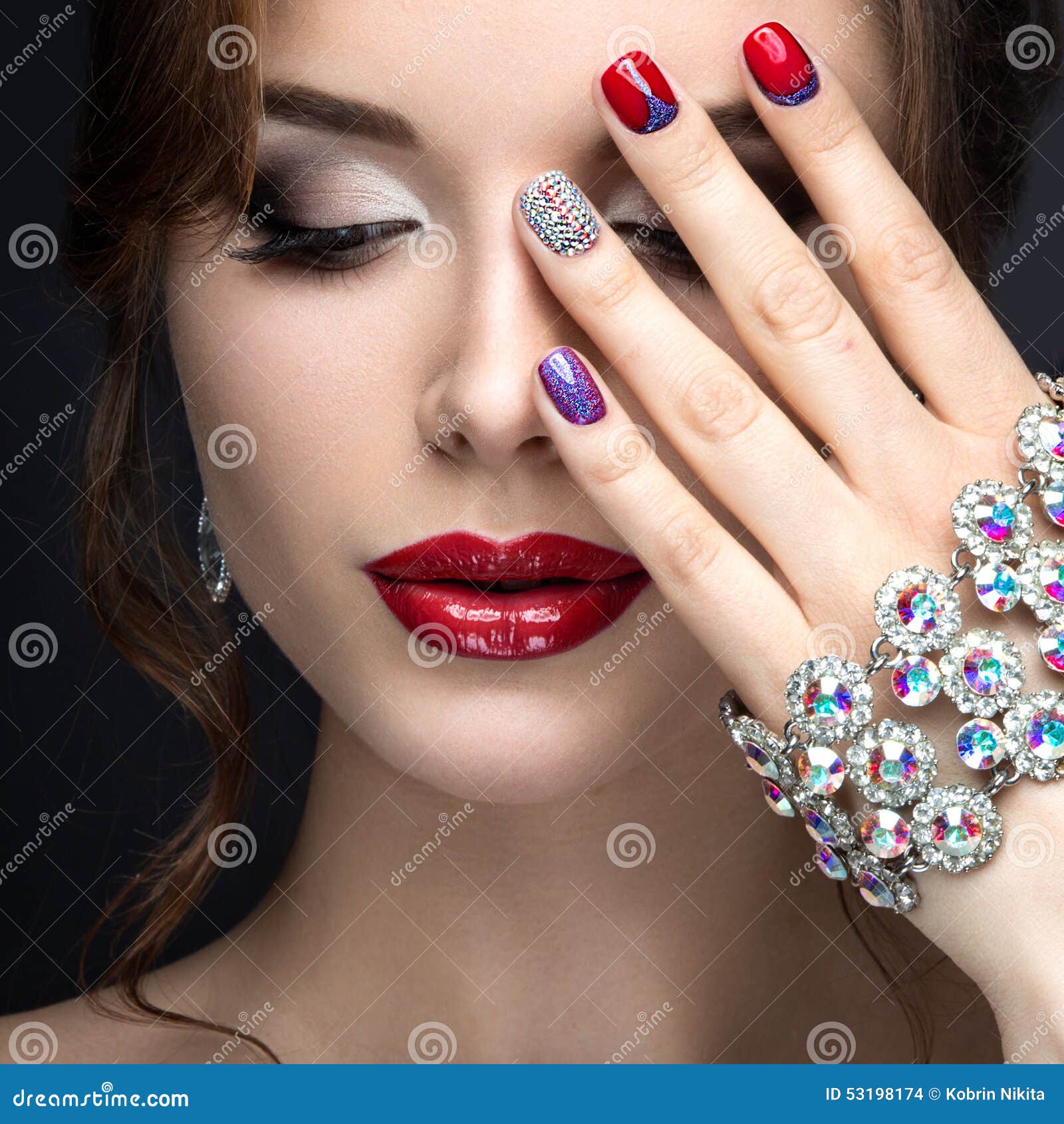 beautiful girl with a bright evening make-up and red manicure with rhinestones. nail . beauty face.