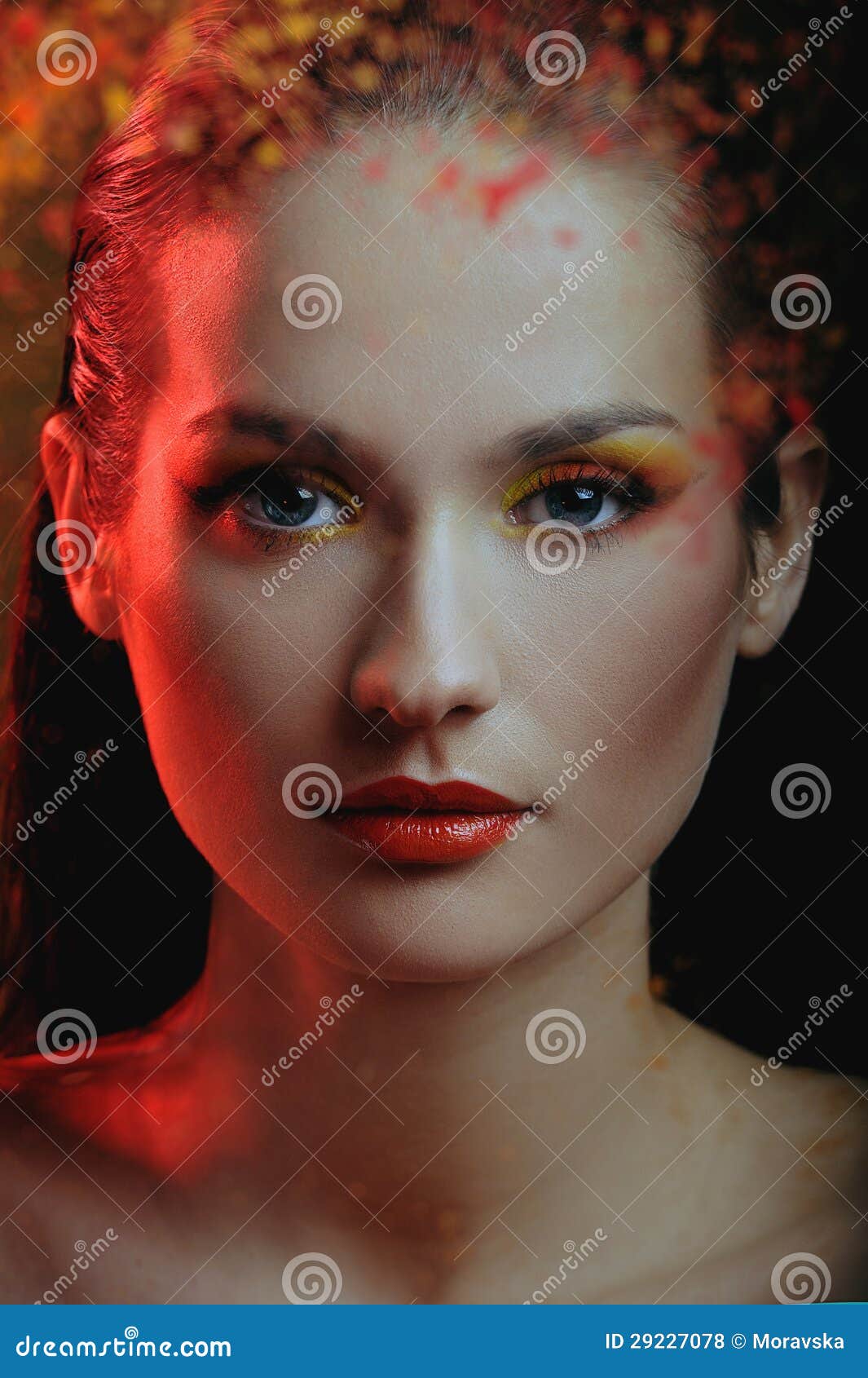 beautiful girl in color paint splash behind the painted color glass in red light