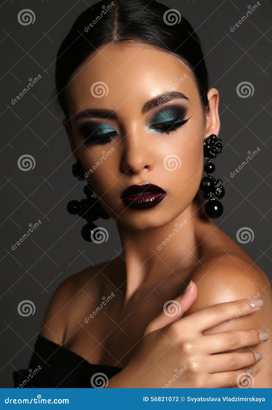 beautiful girl with dark hair with bright extravagant makeup and bijou