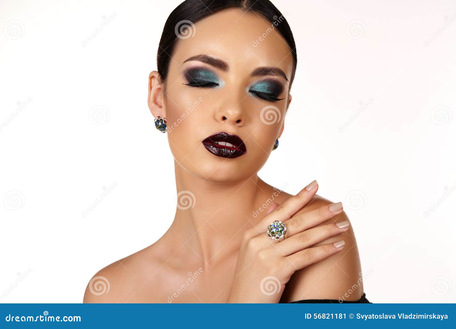 Fashion studio portrait of beautiful girl with dark hair with bright extravagant makeup and bijou