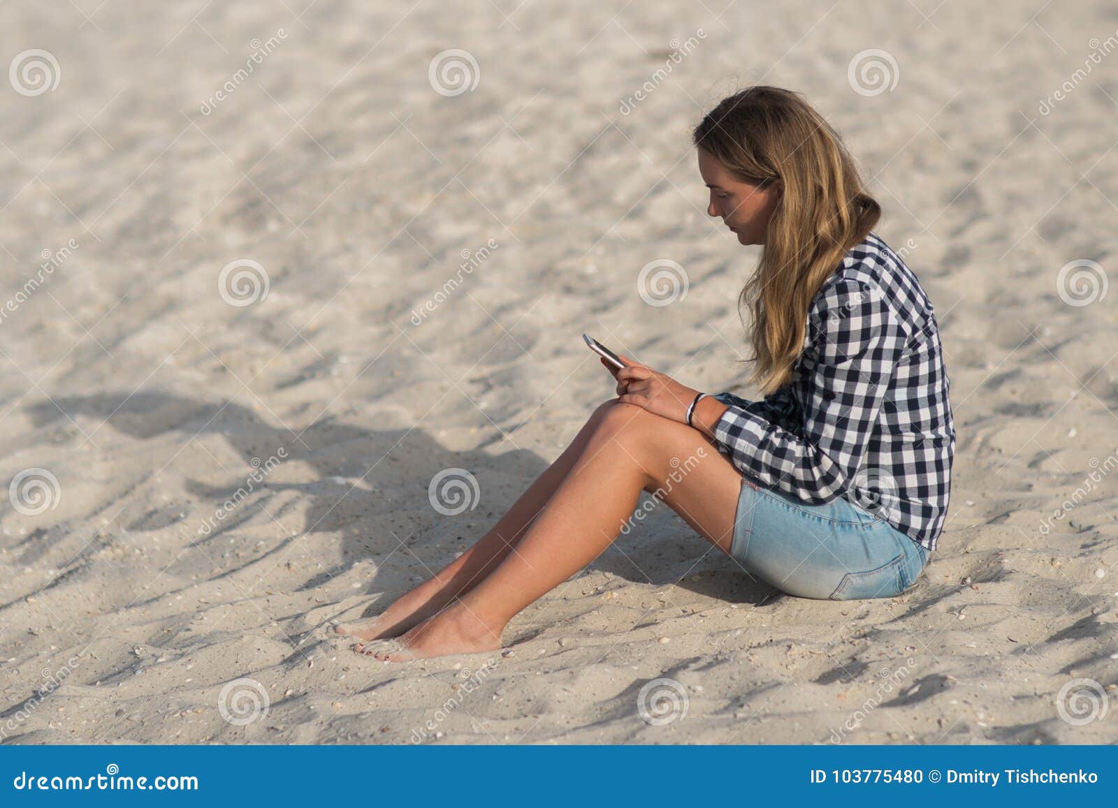 Beautiful Girl Holding A Smartphone In The Hands On The Beach Near The