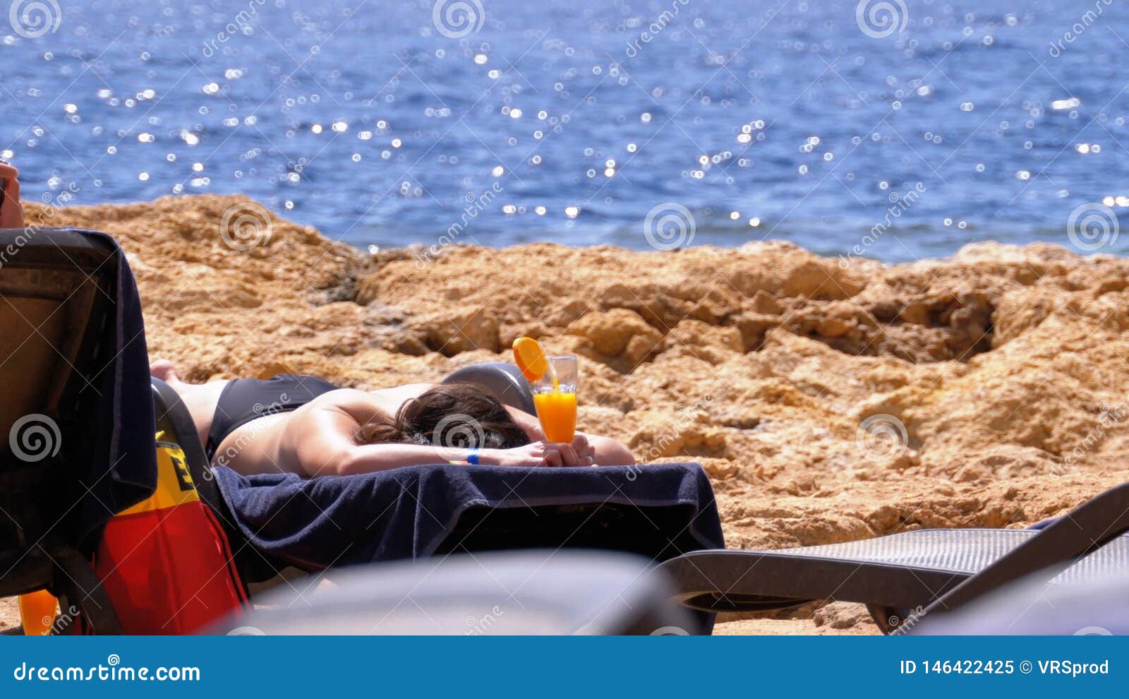 Beautiful Girl Lying On A Lounger On The Beach With A Cocktail In The Glass In Her Hands Stock 