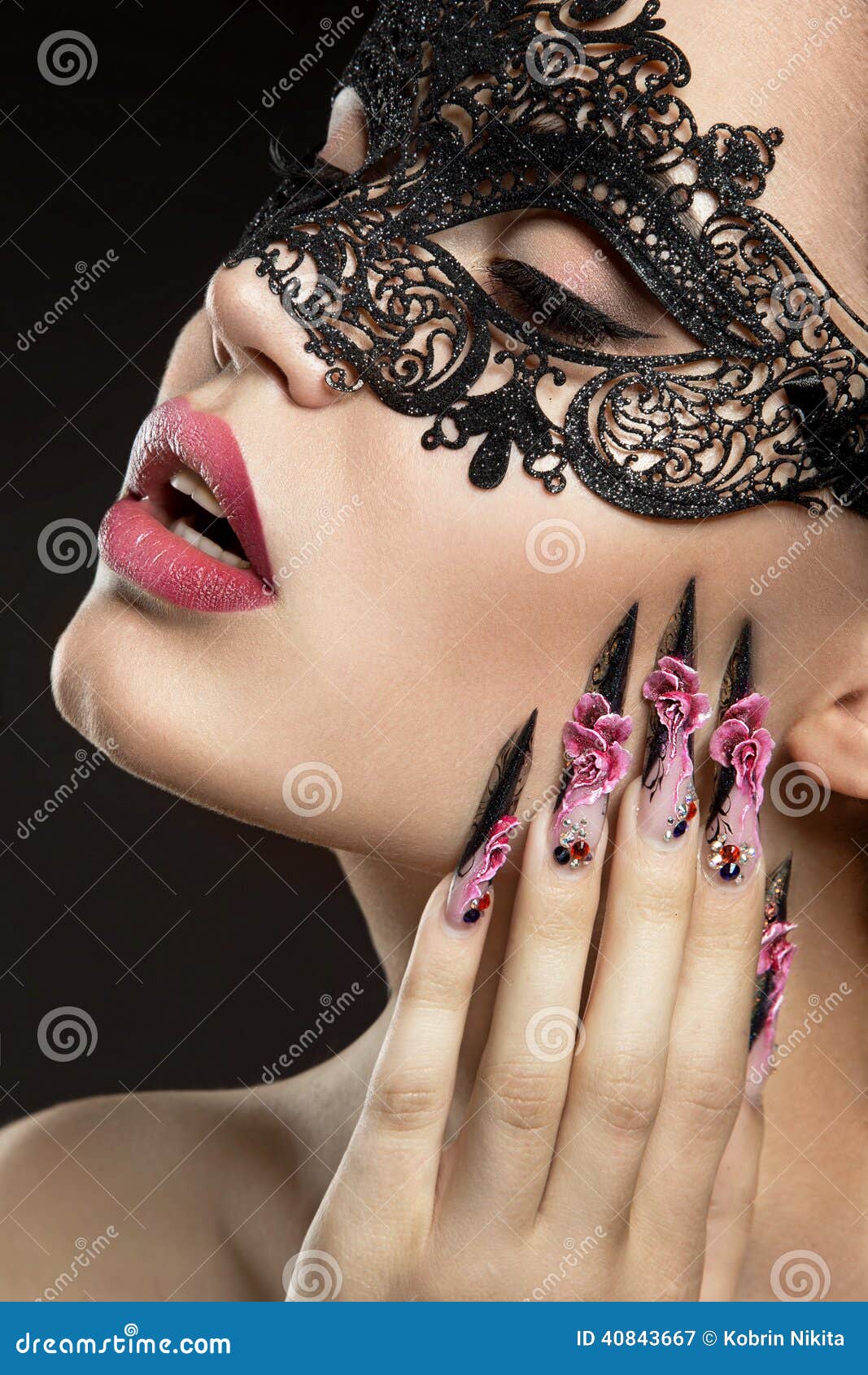 beautiful girl in a mask with long fingernails.
