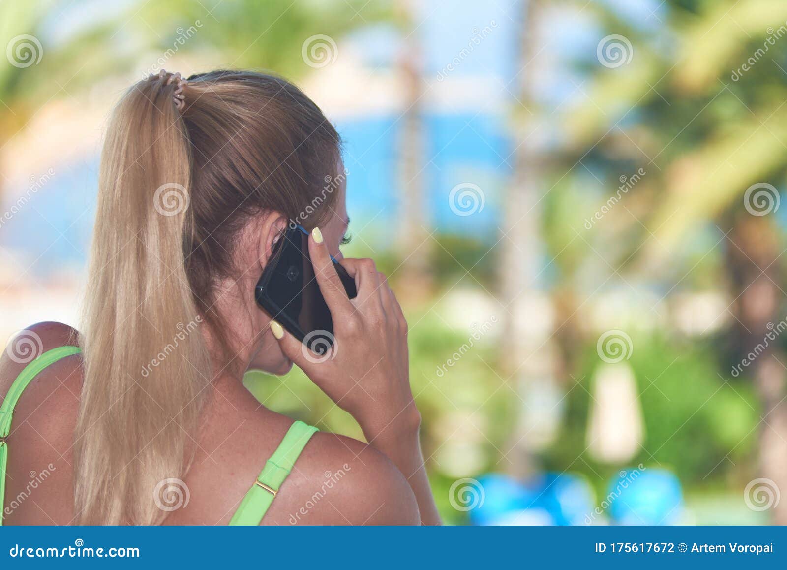 beautiful girl with ponytail calling phone against beautiful sea view