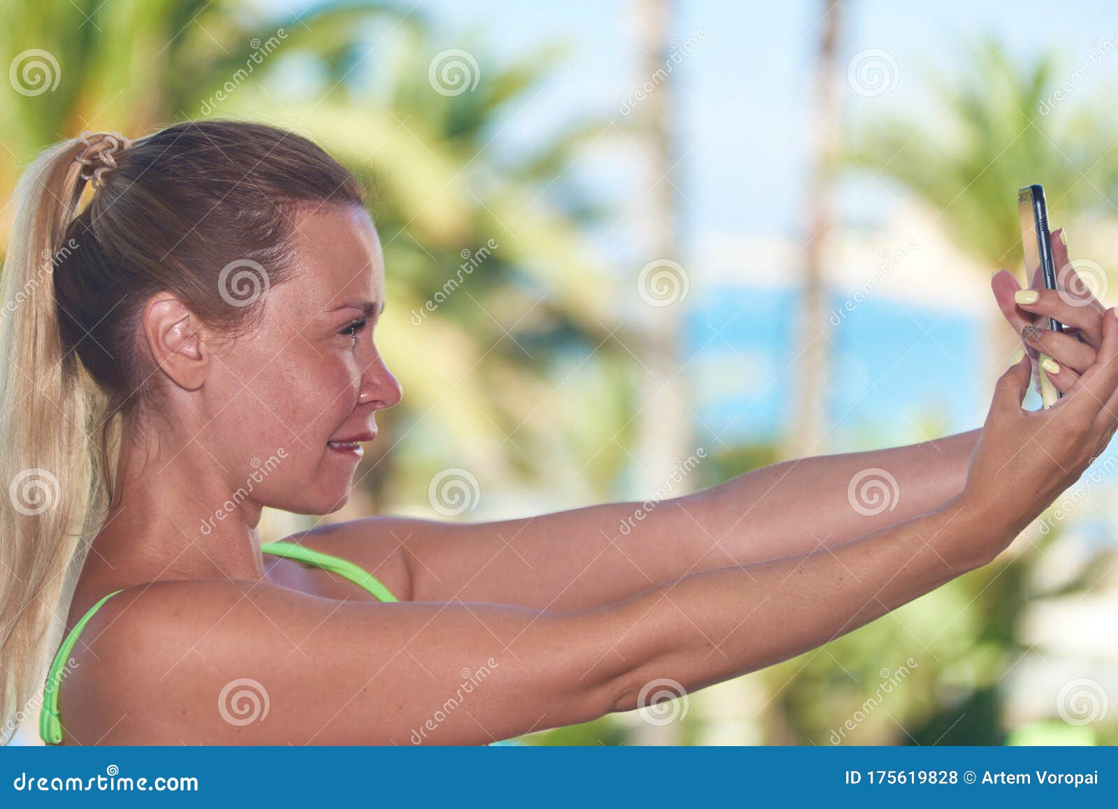beautiful girl with ponytail doing selfie against beautiful sea view