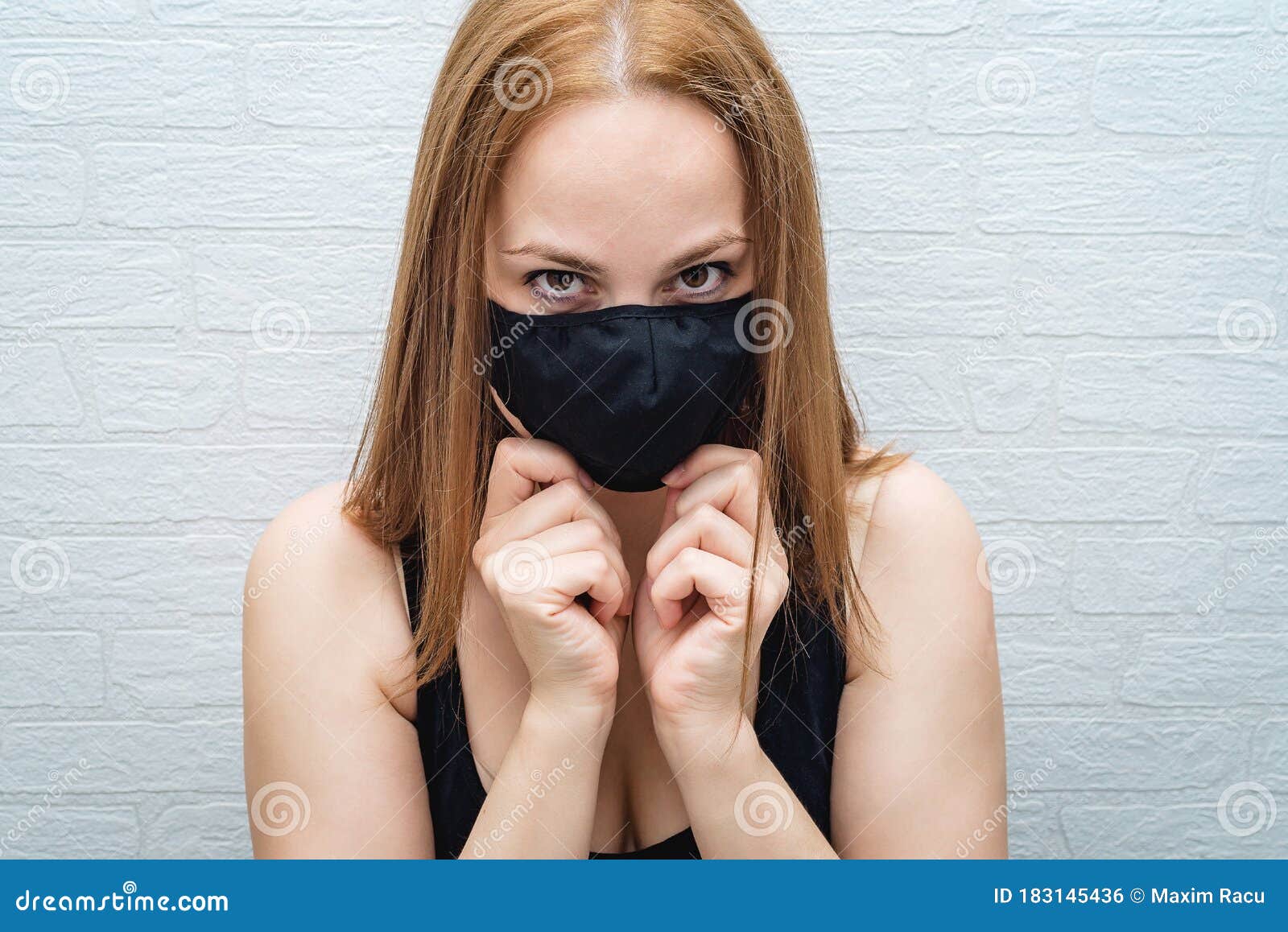 Beautiful Girl Puts On A Black Medical Mask Against A Brick Wall Danger Of The Virus Stock