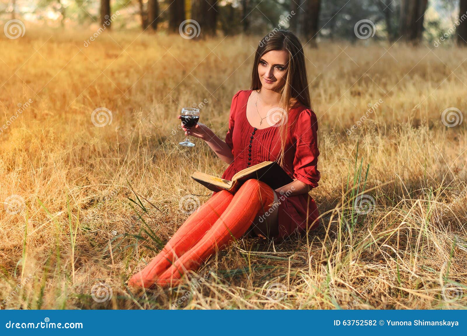 Beautiful Girl Reading A Book With A Glass Of Wine Stock