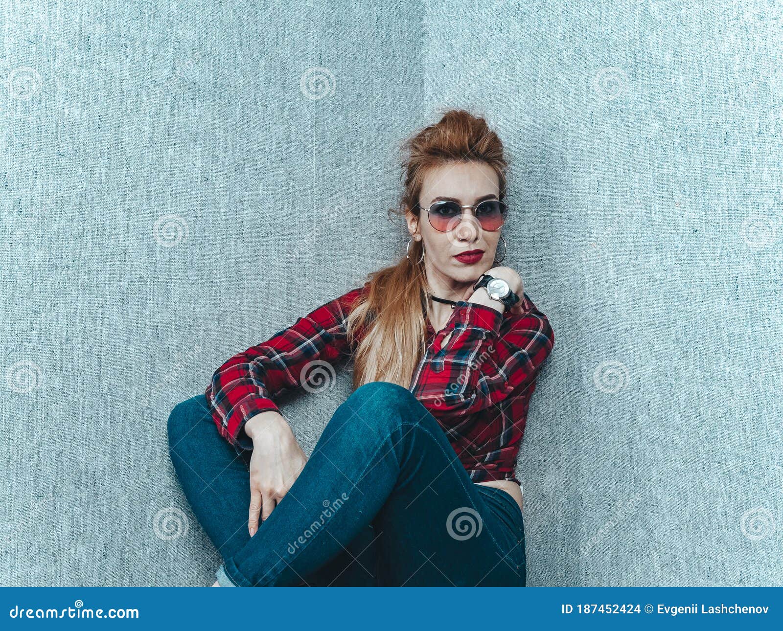 A Beautiful Girl in a Red Shirt with Glasses and with a Clock on Her Hand  Sits Near the Wall with Gray Wallpaper Stock Photo - Image of hipster,  emotion: 187452424