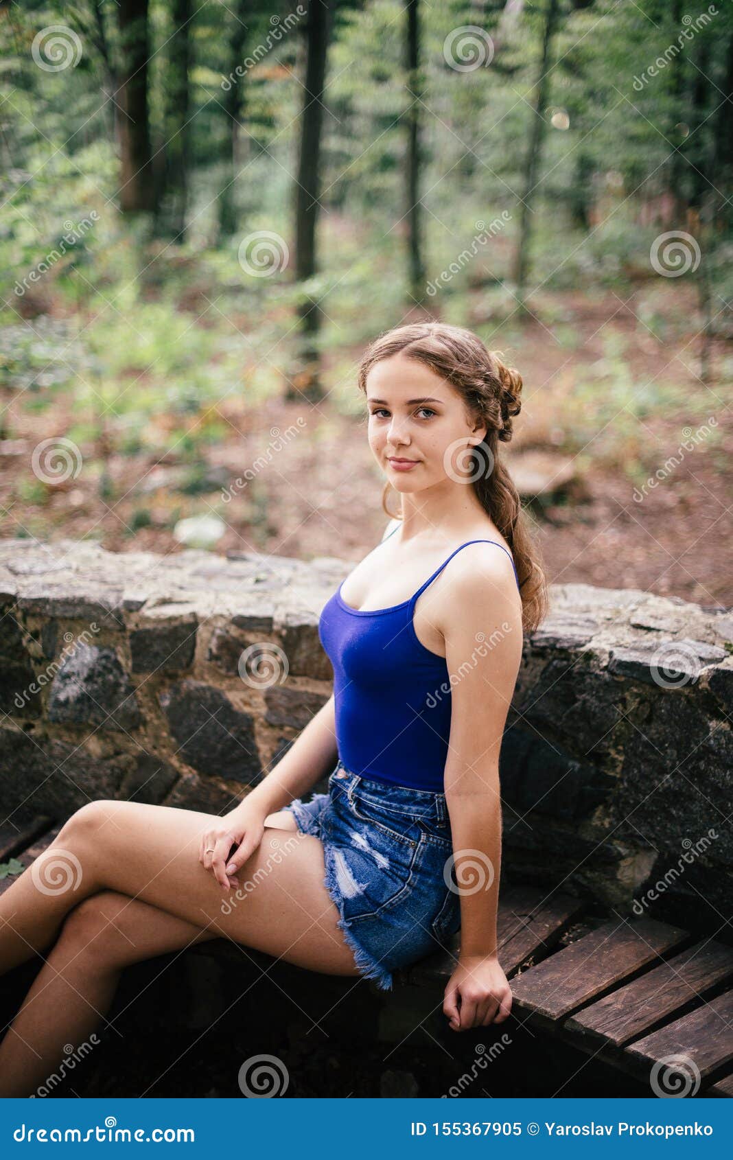 Beautiful Girl in Short Shorts and a Blue T-shirt in the Woods Stock ...